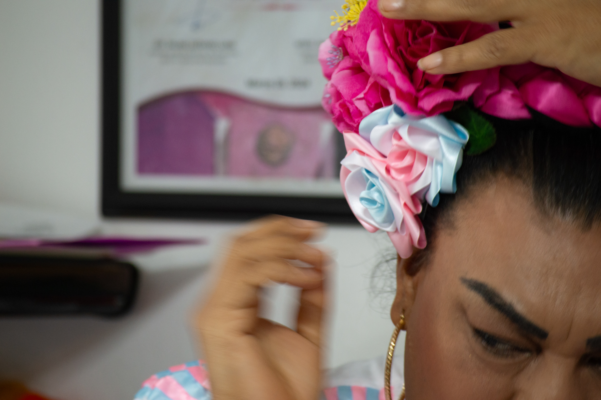 Susana Barrales wears roses in trans flag colors as part of her traditional Mexican folklore dance uniform.