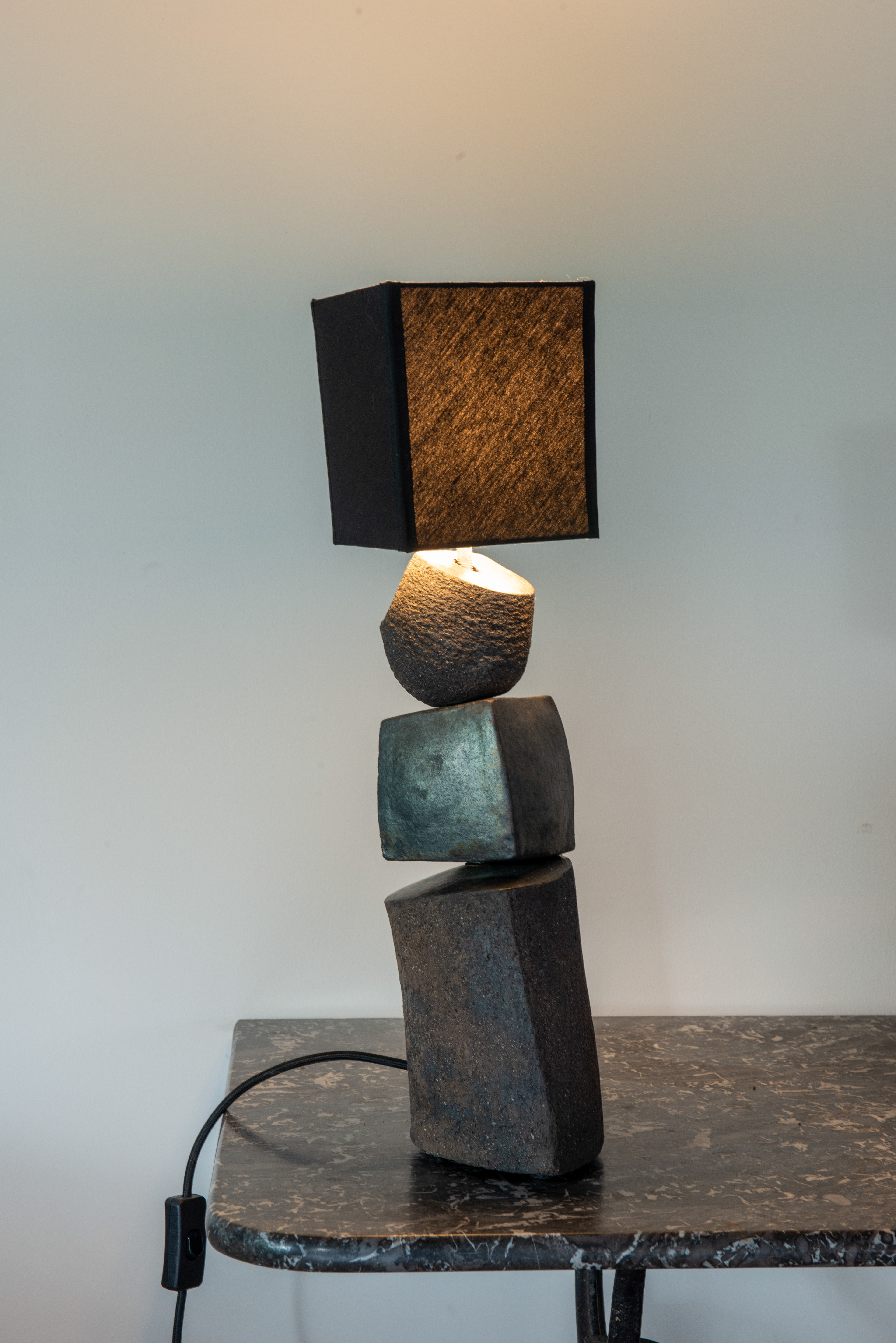 Terre grès noire, cuisson réduction en fosse. Abat-jour coton. H : 52cm