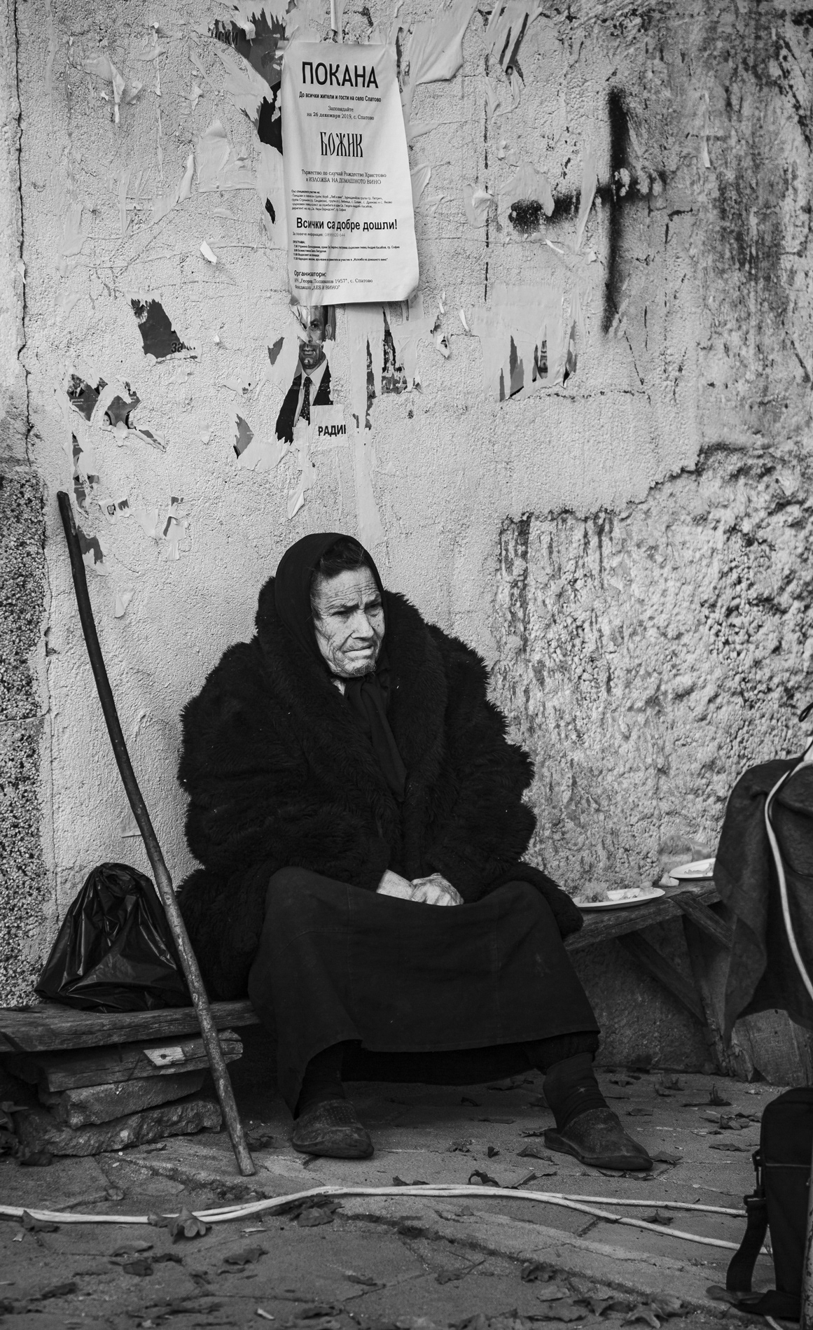 An elderly woman observing the celebrations from the side.