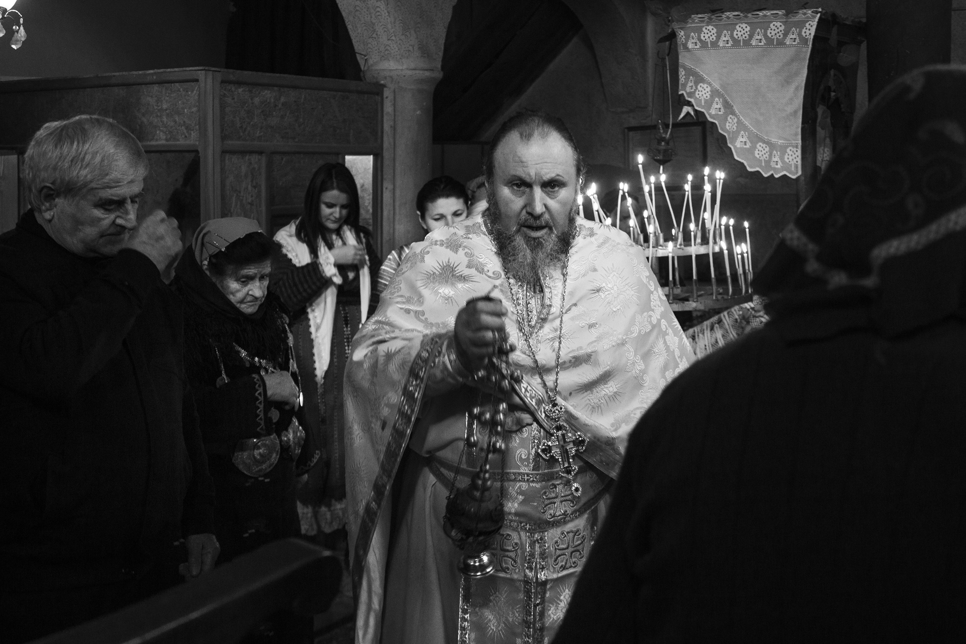 The local priest during the early morning sermon at the village's church.