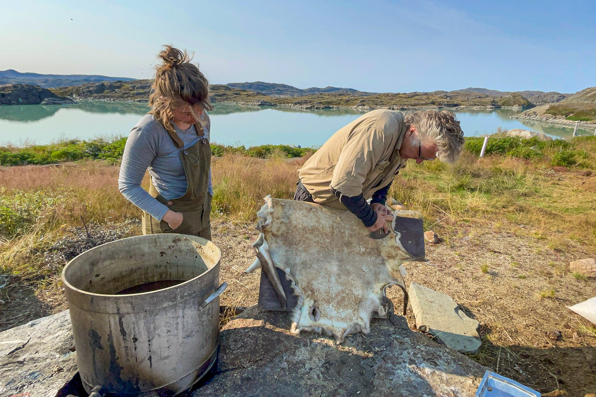 Stefan showing me how to scrape with an ulu. (Photo by Carson Brown)