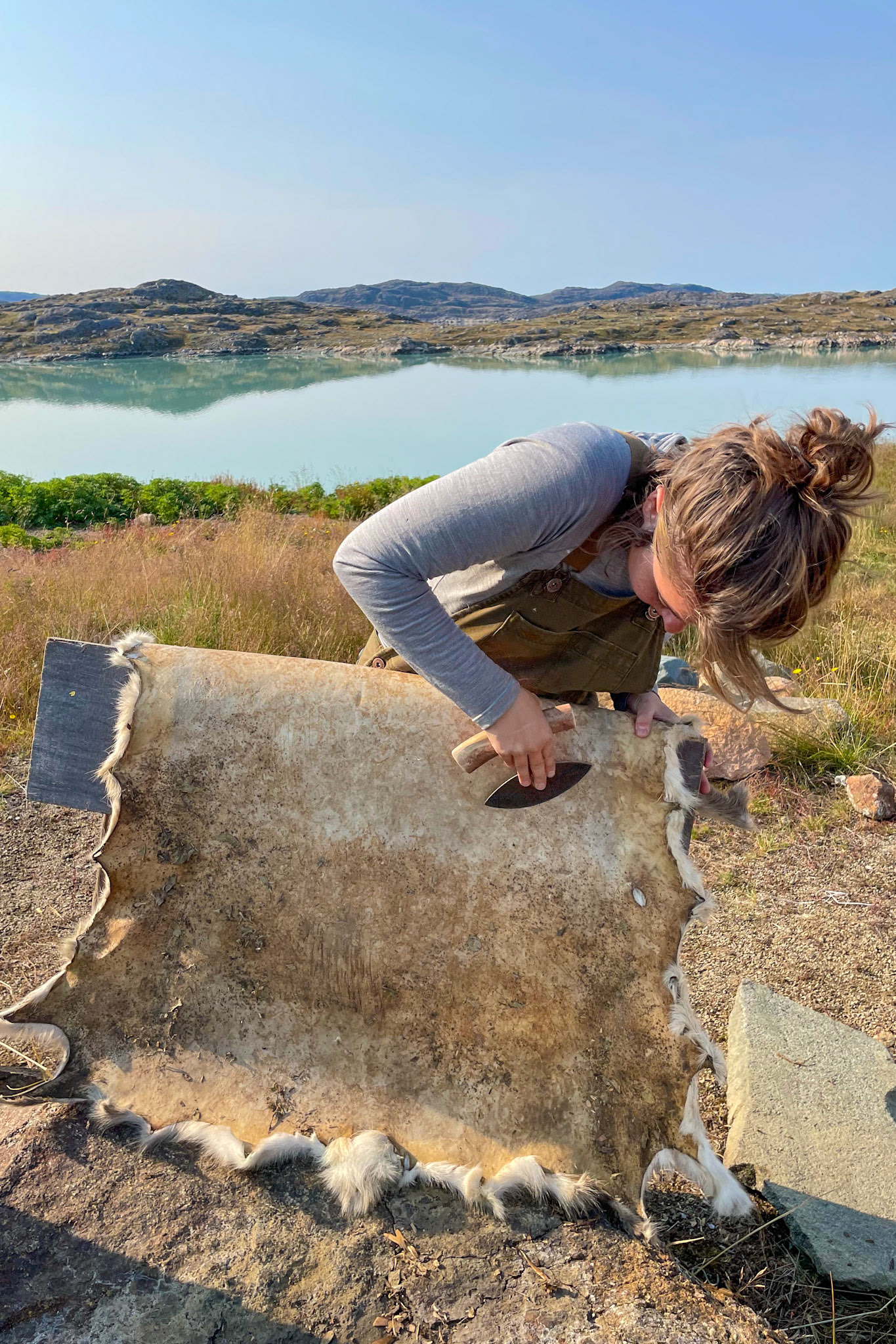 Putting the lesson into practice and scraping my reindeer skin. (Photo by Carson Brown)