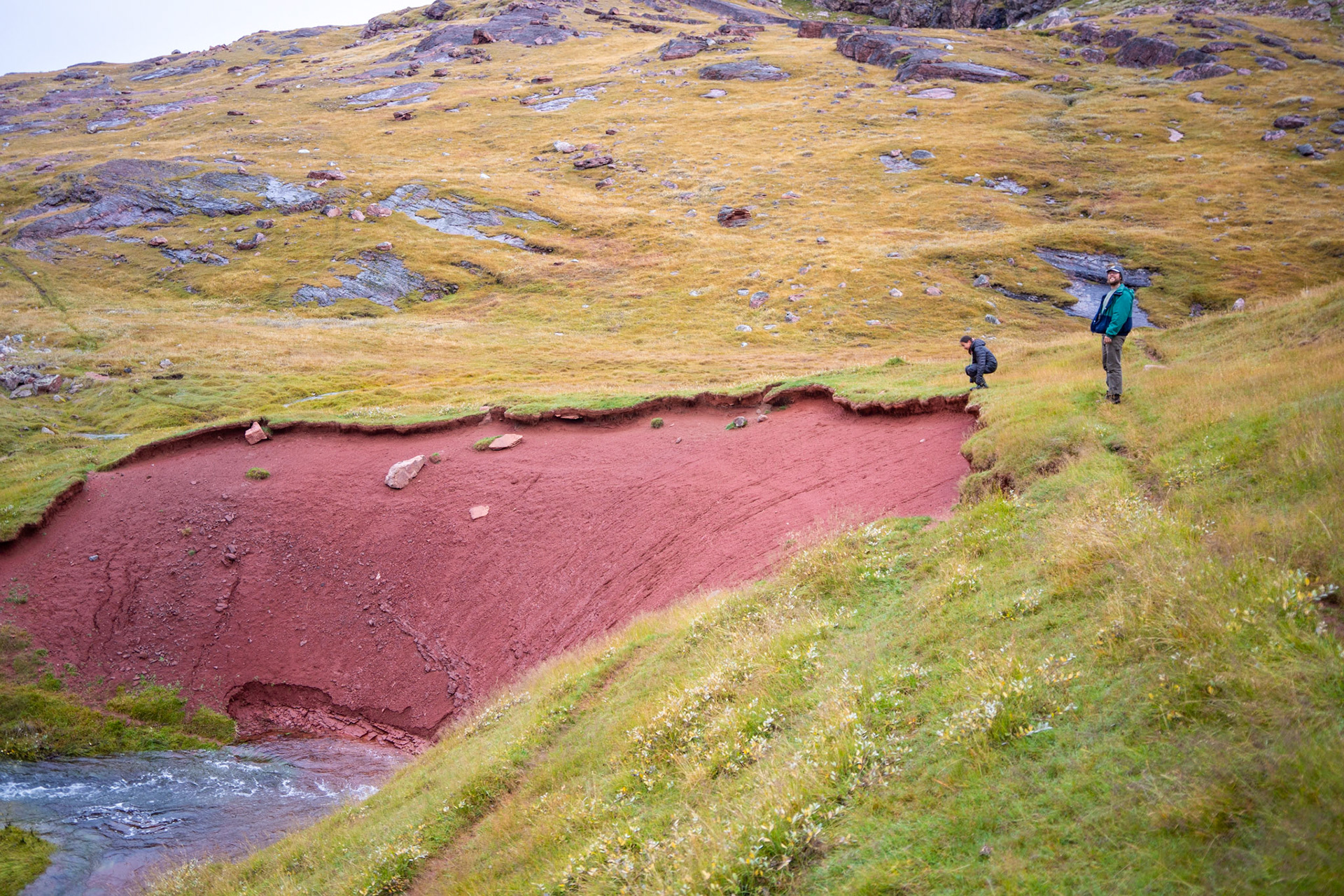 Kira and Carson by some red clay soil around the Qassiarsuk area.