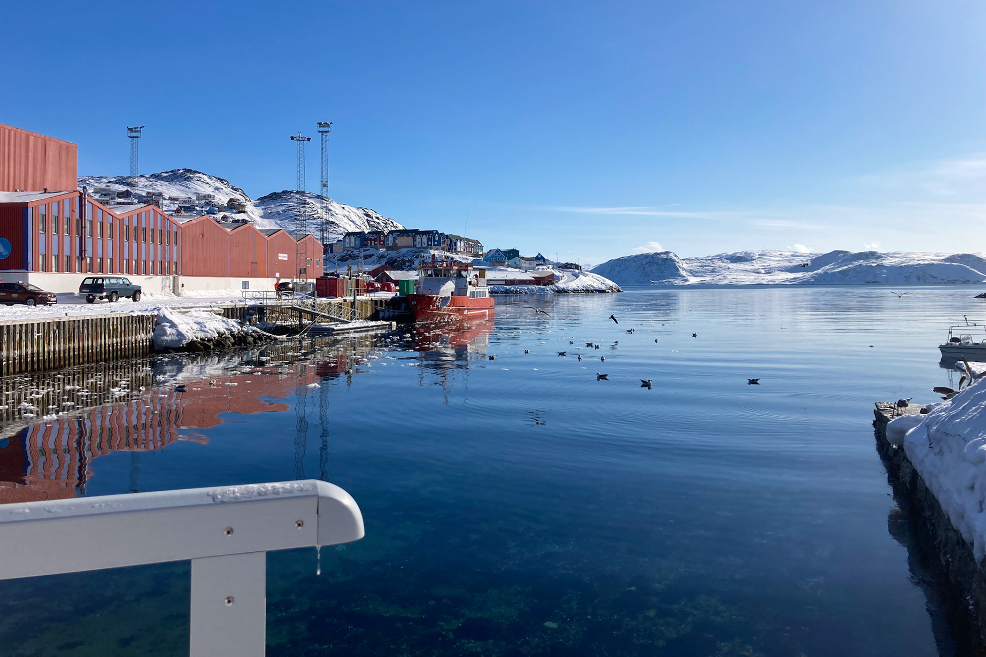 Qaqortoq, from the view of the bridge next to Kalaalimineerniarfik. To the left you can see the office of UNESCO Kujataa and Innovation South Greenland (the blue and red striped piece of the harbor building). The other half of the building is used for Royal Greenland shipping. (Taken on my phone)