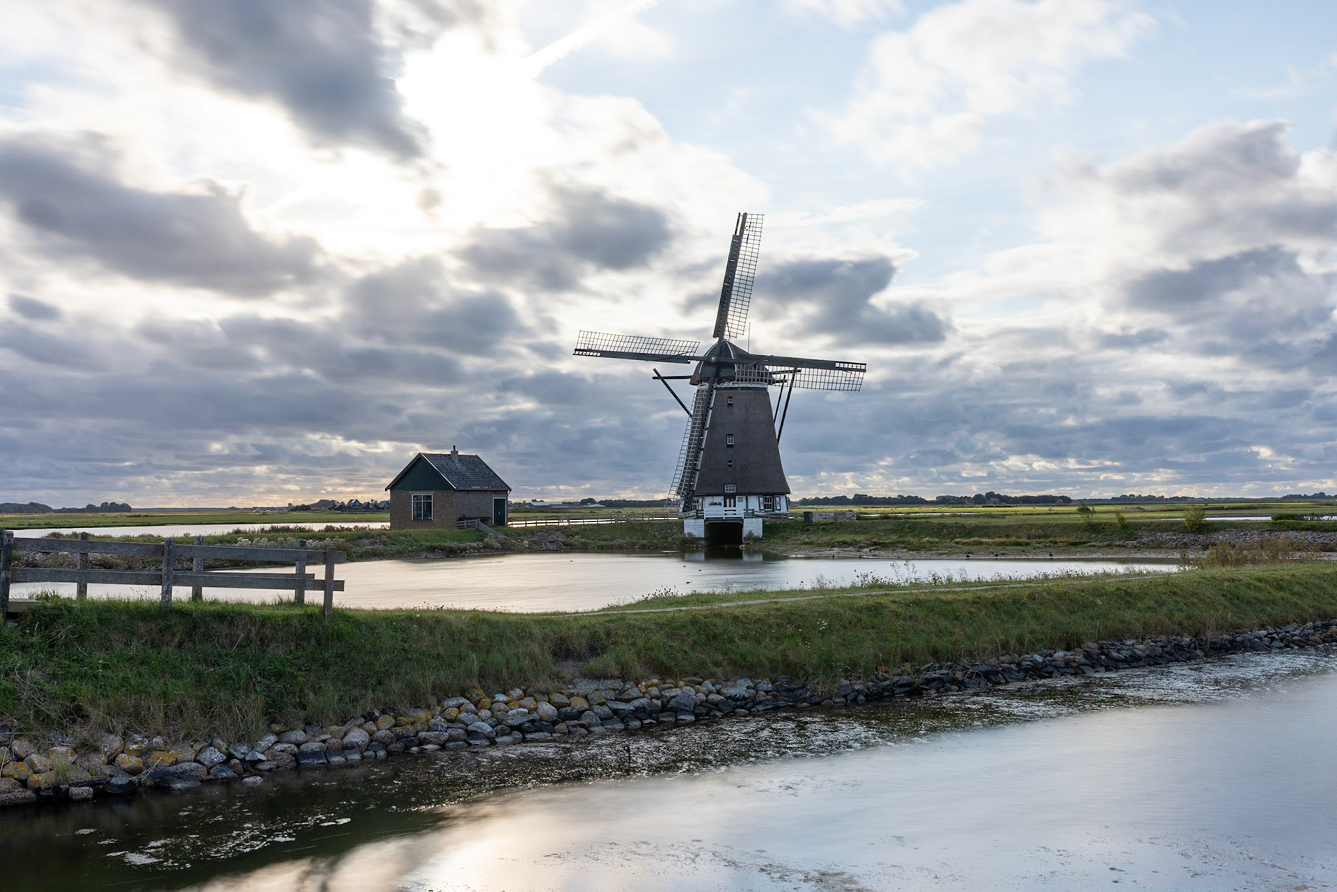classic dutch windmill in the middle of small lakes