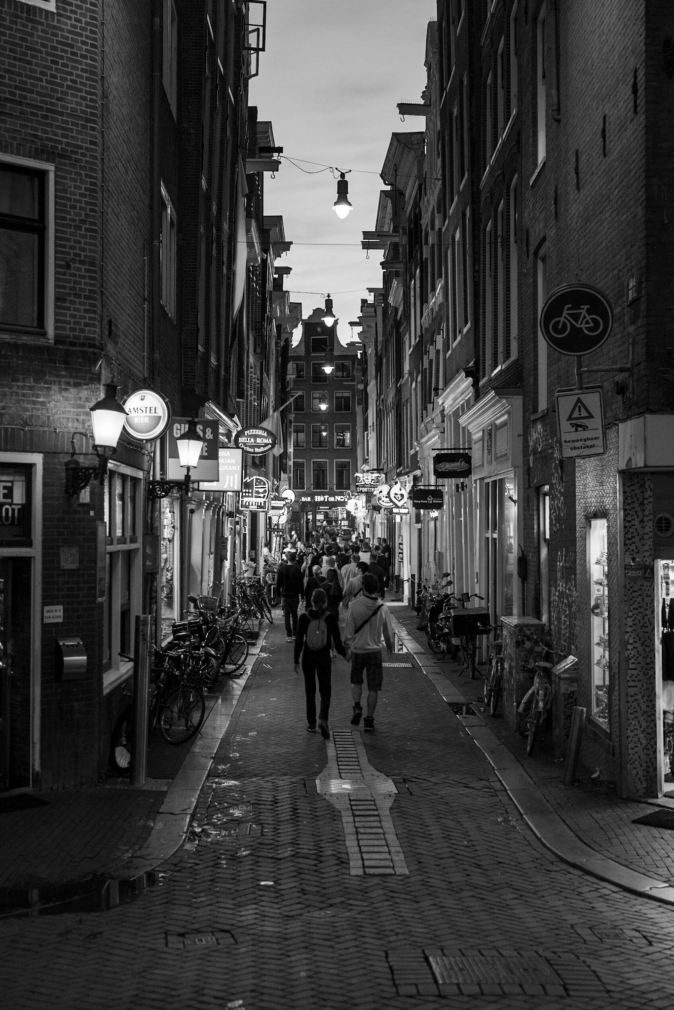 the streets of amsterdam at night, brightly lit by the neon lights of the stores