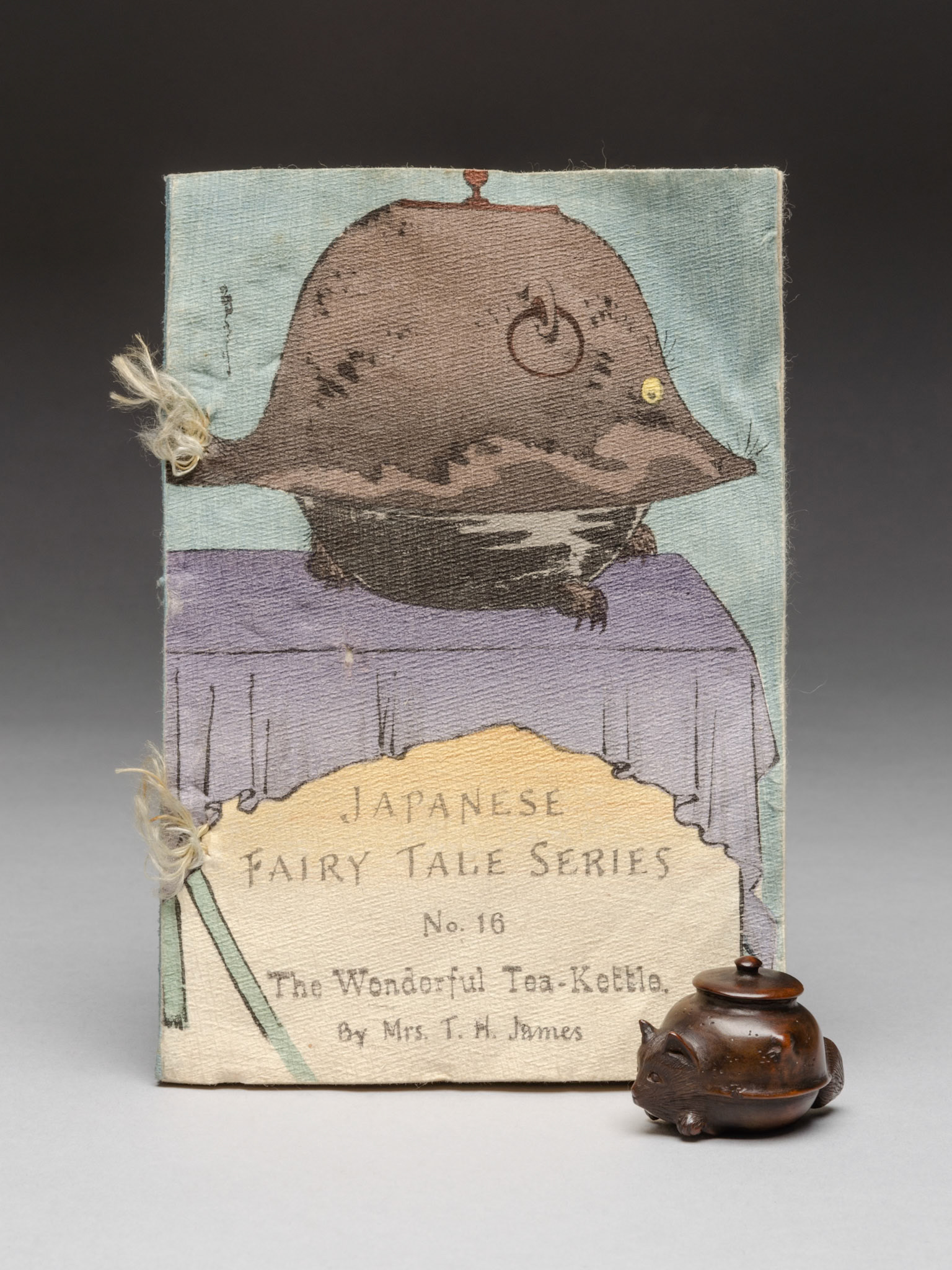 Z 36443, illustrated book by Mrs T H James and 1943.106, 'netsuke of a badger-kettle', Japan, © Museum of Archaeology and Anthropology, University of Cambridge