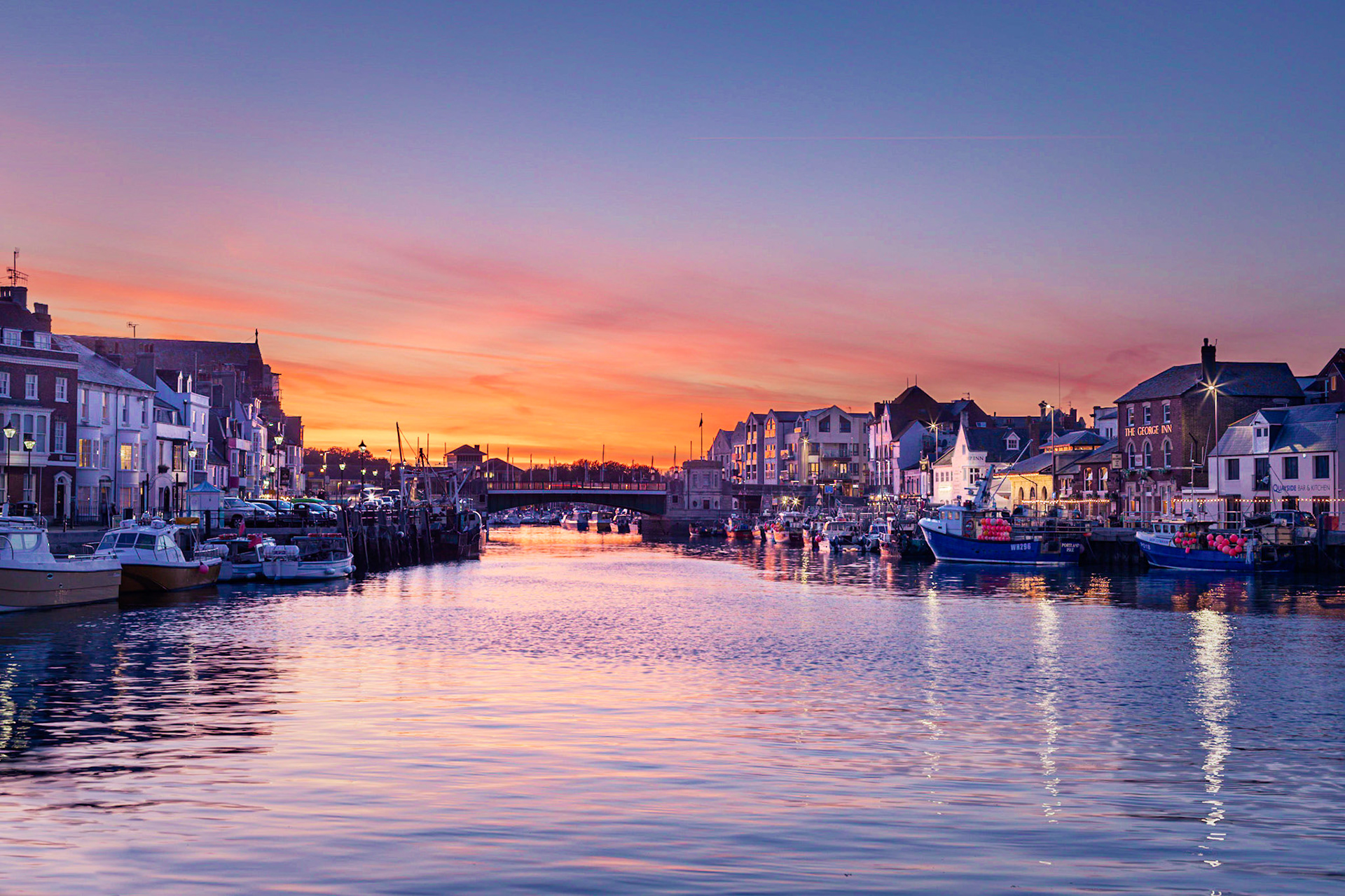 Weymouth’s famous vibrant harbour in the heart of the Jurassic Coast in Dorset as the sun sets and light turns to night in October