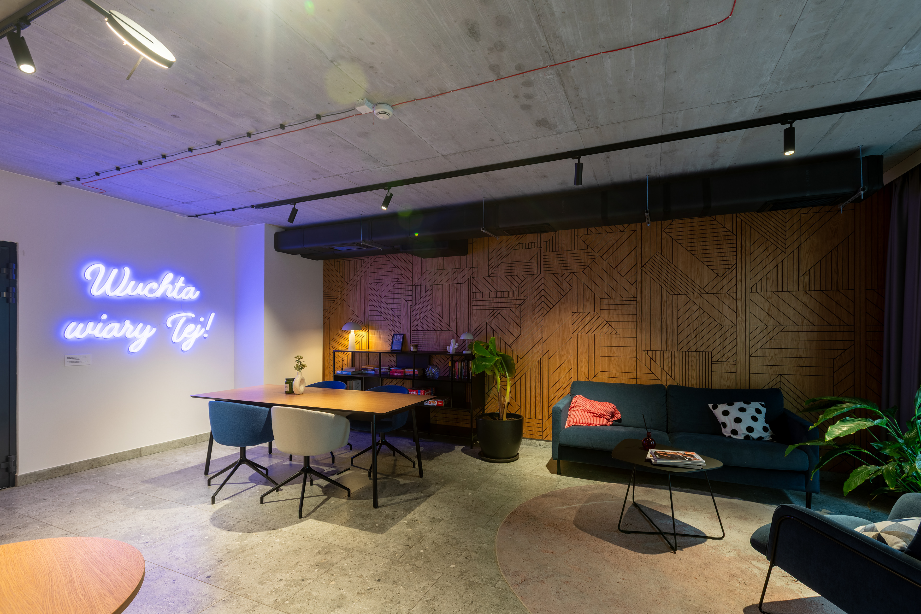 Coworking z neonem i betonowym sufitem – projekt ISA Architekci