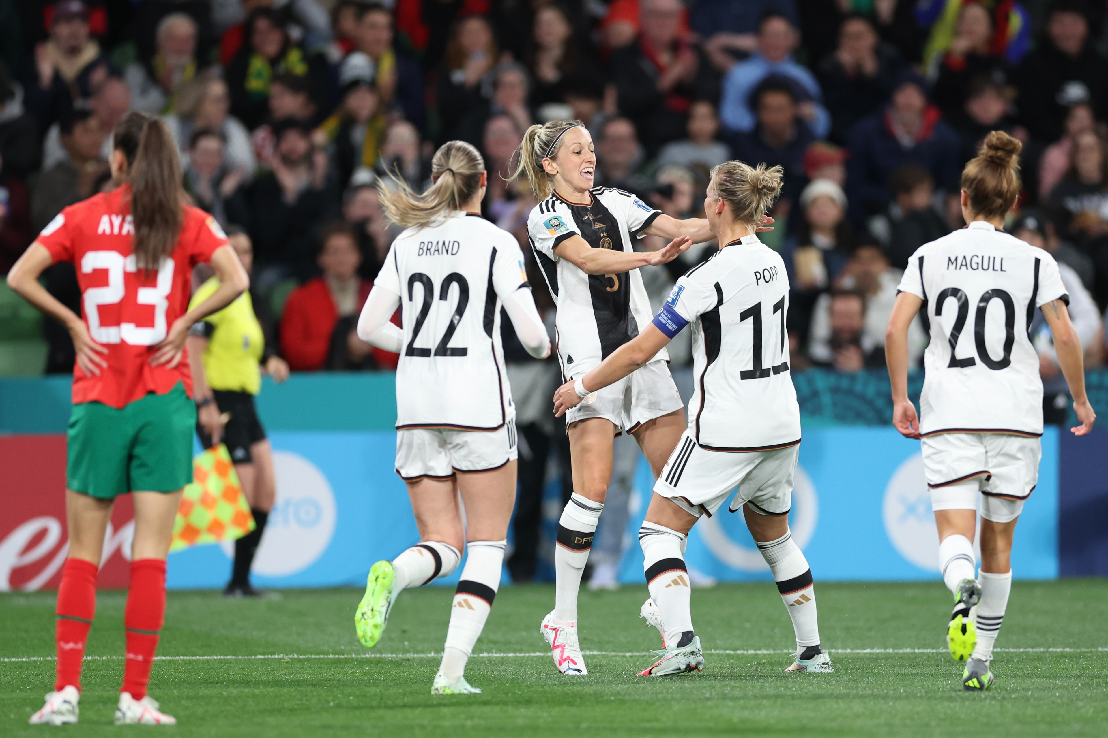Germany's Kathrin Hendrich, centre left, reaches out to celebrate with teammate Alexandra Popp after she scored the opening goal during the Women's World Cup Group H soccer match between Germany and Morocco in Melbourne, Australia, Monday, July 24, 2023. (AP Photo/Victoria Adkins)