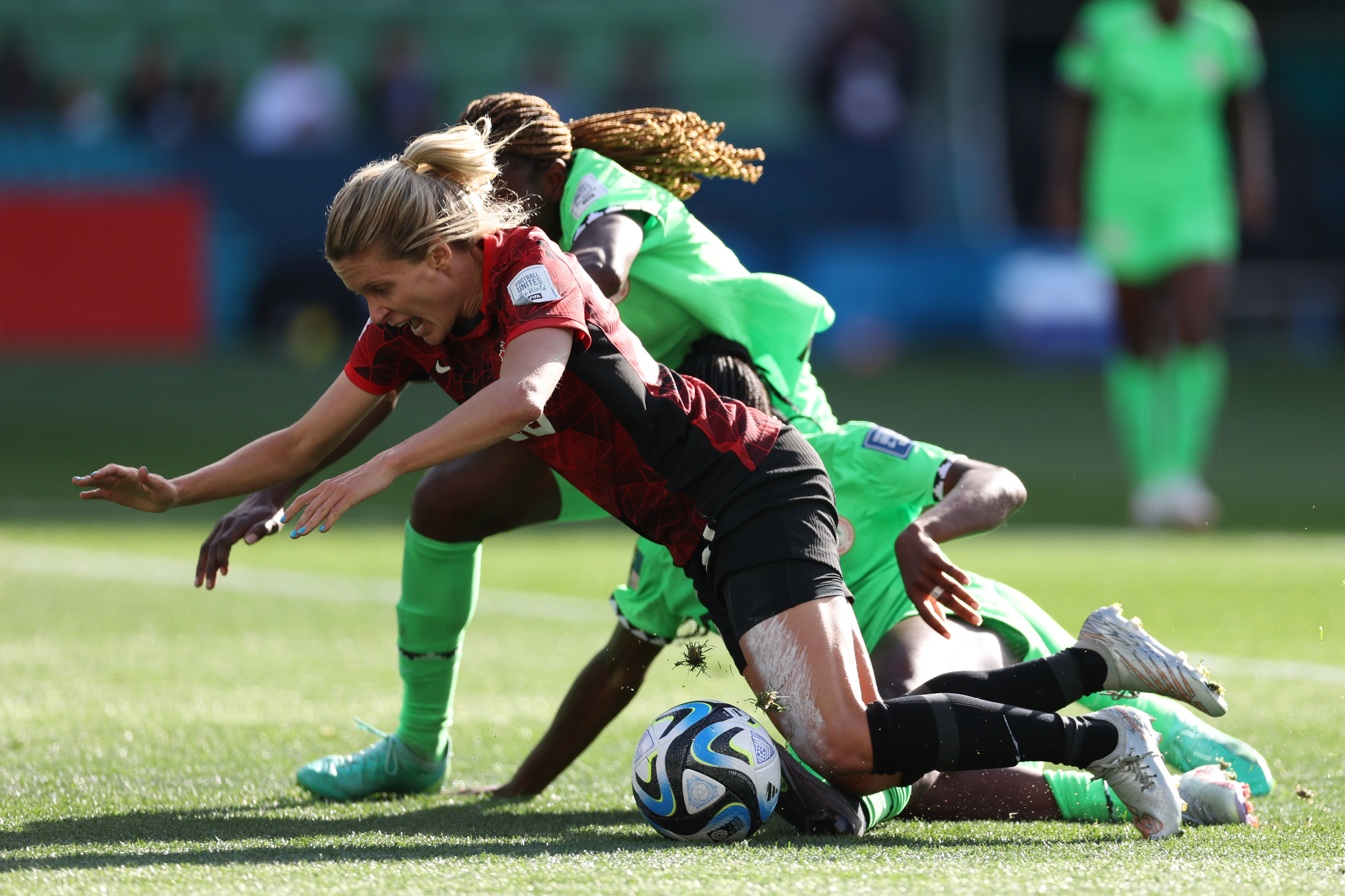 Canada's Cloe Lacasse falls after colliding with Nigeria's Michelle Alozie, right, and Nigeria's Christy Ucheibe, back, during the Women's World Cup Group B soccer match between Nigeria and Canada in Melbourne, Australia, Friday, July 21, 2023. (AP Photo/Victoria Adkins)