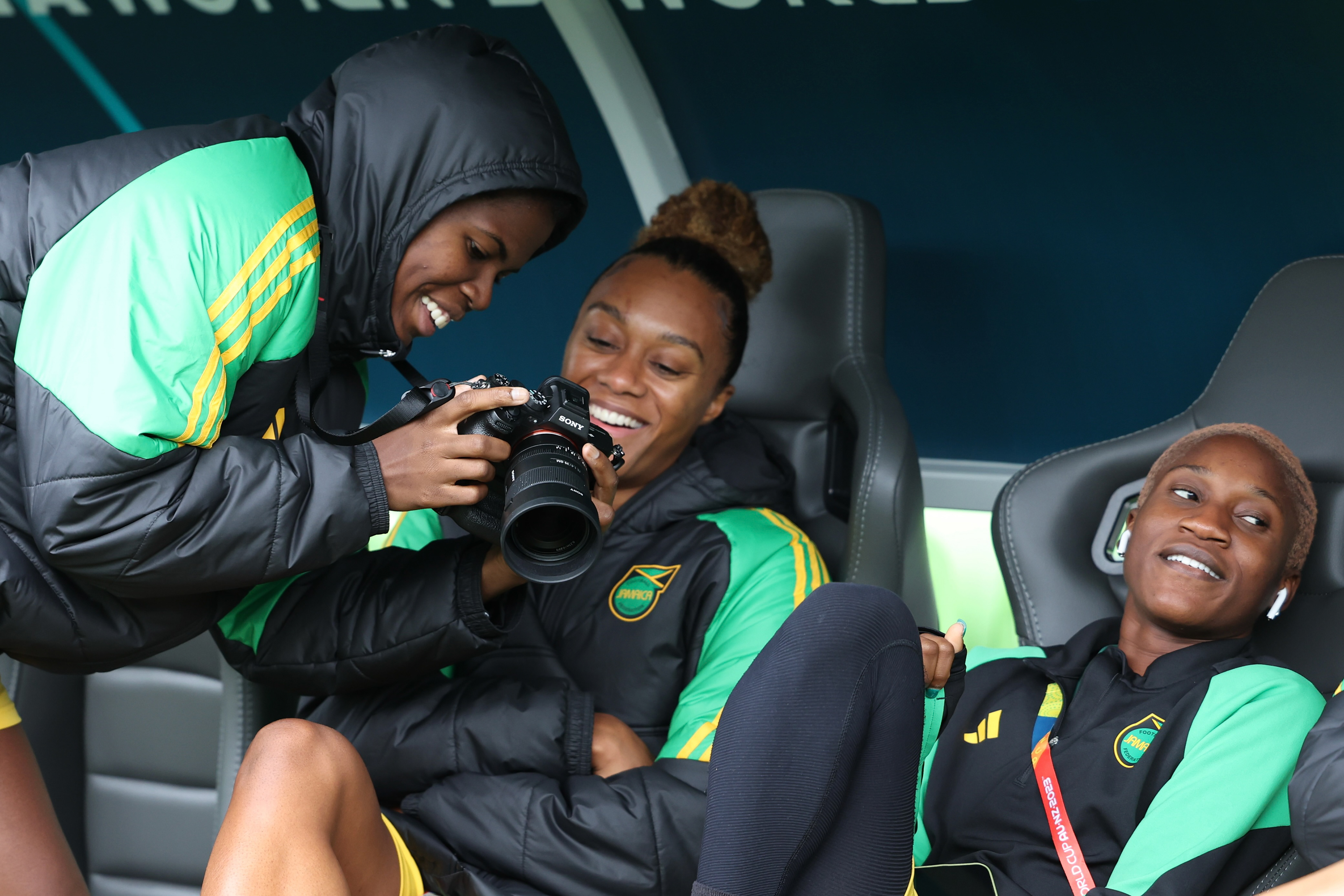 Jamaica's Khadija Shaw, left, shows a photo to teammate Chantelle Swaby during a familiarization visit to Melbourne Rectangular Stadium before a Women's World Cup Group F match against Brazil in Melbourne, Australia, Tuesday, Aug. 1, 2023. Two crowd funding project have raised more than US$98,000 to support the team through the tournament. (AP Photo/Victoria Adkins)