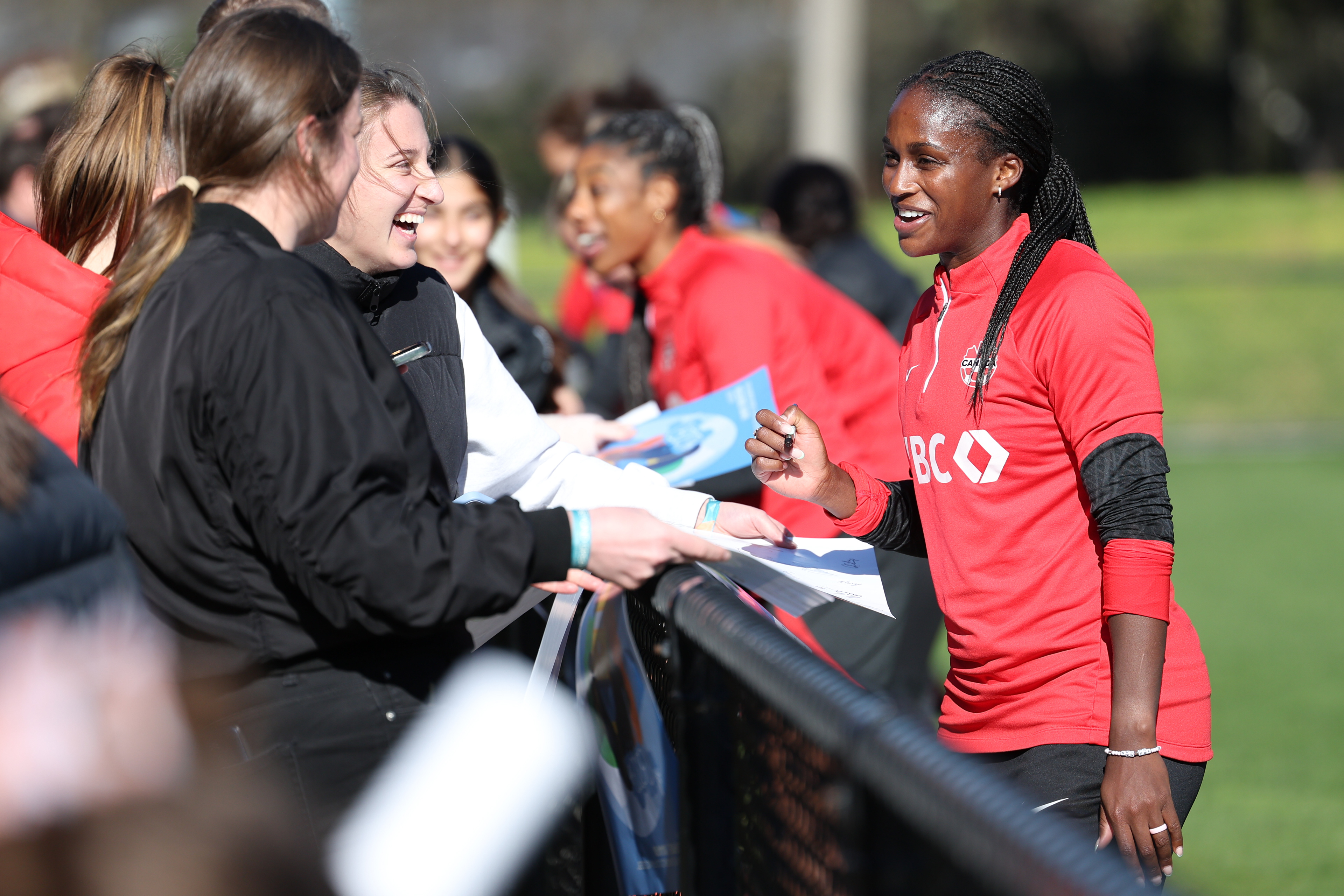 Canadian player Nichelle Prince signs a poster for a fan after practice ahead of the Women's World Cup in Melbourne, Australia, Monday, July 17, 2023. Canada held a public training session ahead of its opening match with players from Melbourne-based Heidelberg United FC watching the Olympic champions practice on their field, preparing for Friday July 21, 2023 game against Nigeria. (AP Photo/Victoria Adkins)