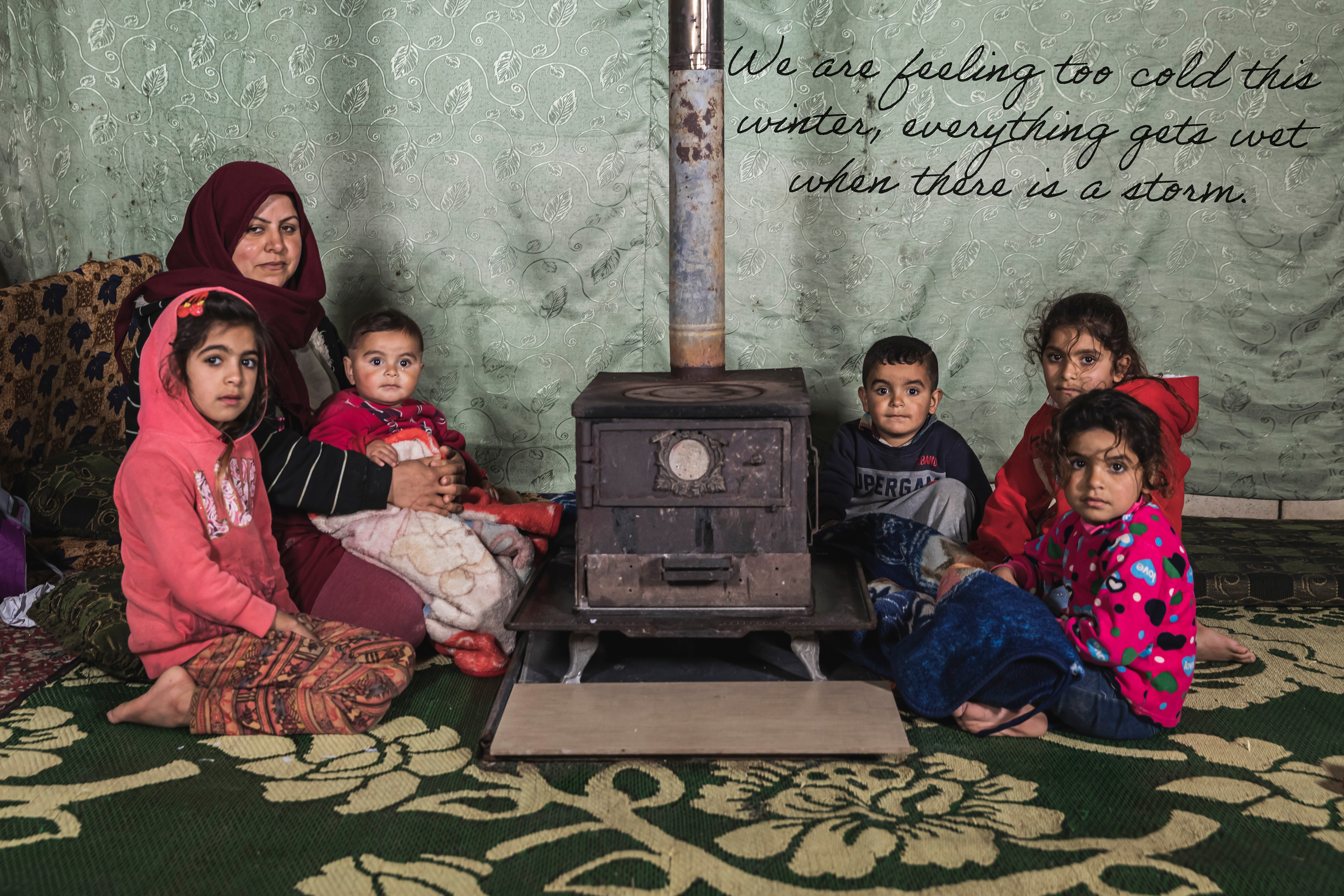 Rima, Lebanese woman and her children next to their empty stove inside their tent in South Lebanon.
