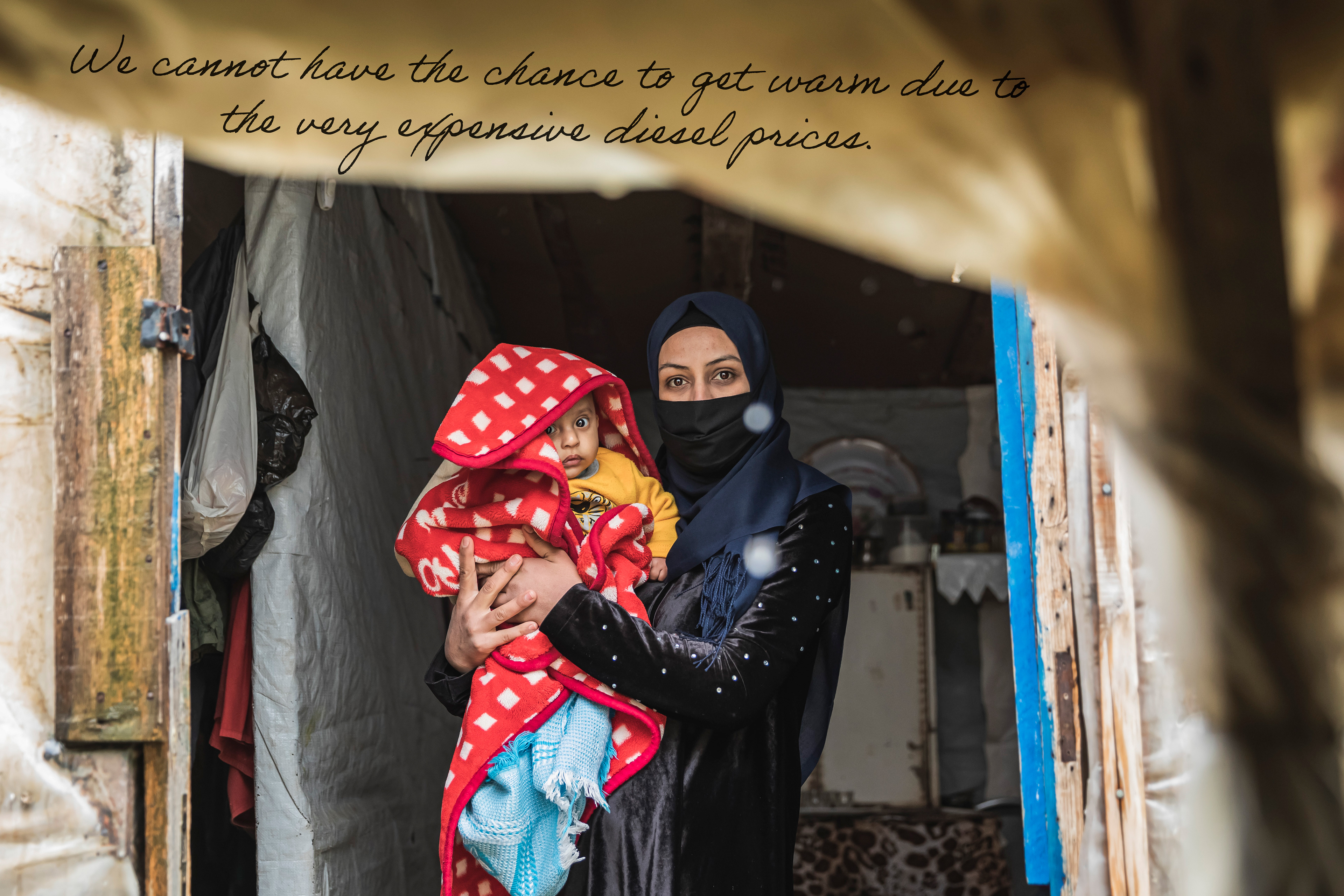 Fatima, Syrian refugee with her baby inside her wet tent in South Lebanon.