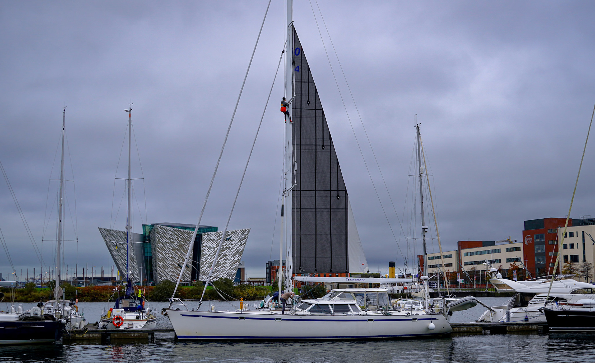 A man fixing the sail in front of the Titanic museum