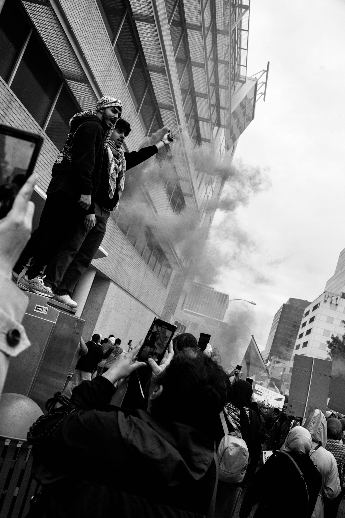 Tariq Dwekat and Zaid Sehwail, from Dallas, release colored smoke grenades above the crowd of thousands. “We all wish to see a liberated Palestine,” Sehwail said.  