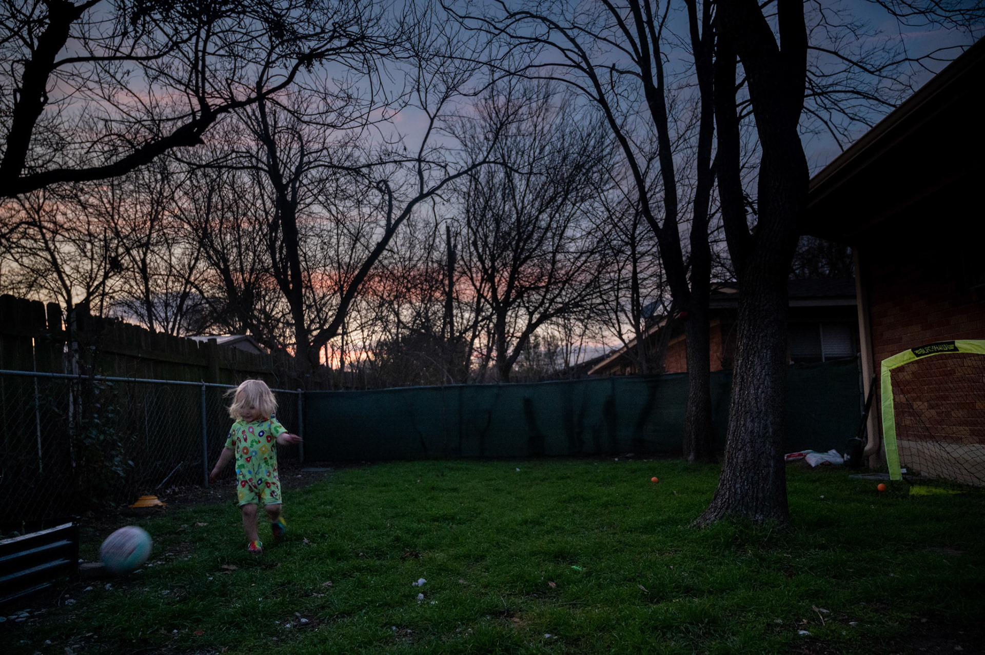 Whitney Morrow cooks dinner on a camping propane stove while two-year-old Shelby plays outside as the sun sets with his dad, Nick, in Wooten, Austin on Feb. 6, 2023.