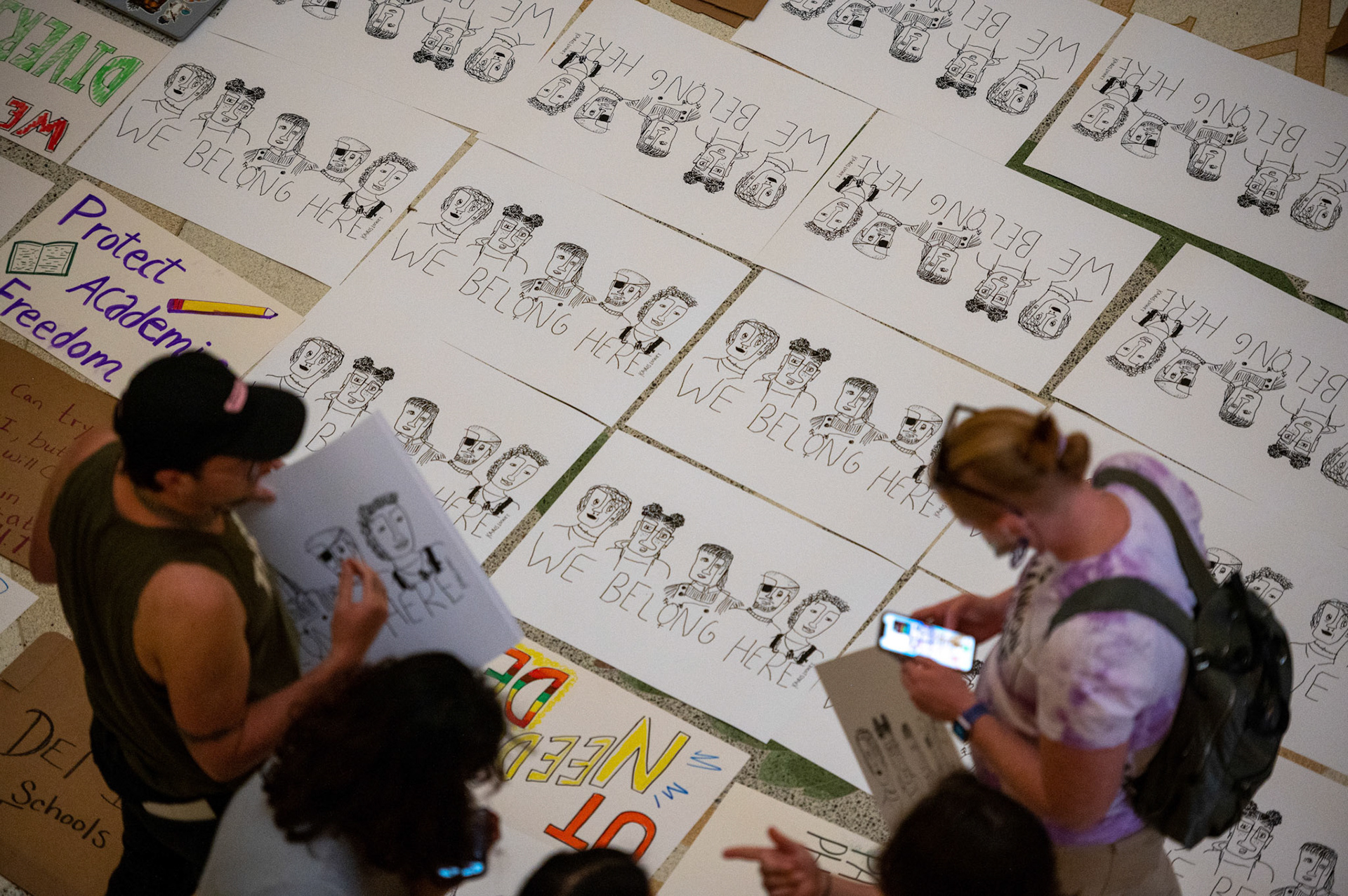 Illustrated posters reading “We Belong Here” litter the Capitol’s rotunda floor during Texas Students for Diversity, Equity and Inclusion’s protest of HB1 Rider No. 186, which would defund DEI initiatives at public universities, on Mar. 23, 2023.