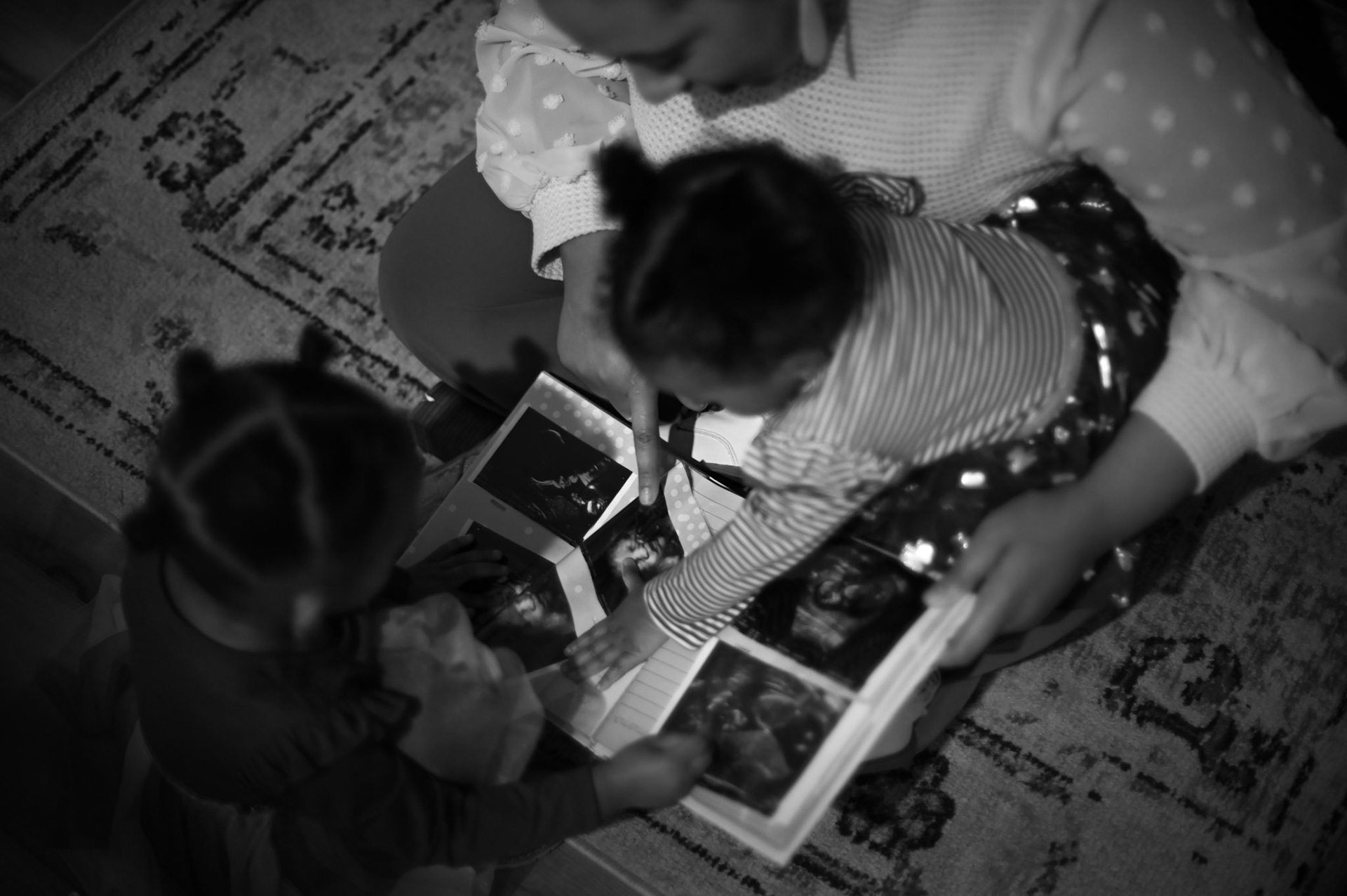 Alexandria Robertson shows her daughters Novah and Kellani-Ari Wilson ultrasound pictures from her pregnancies in Manor, TX on Feb. 2, 2023.