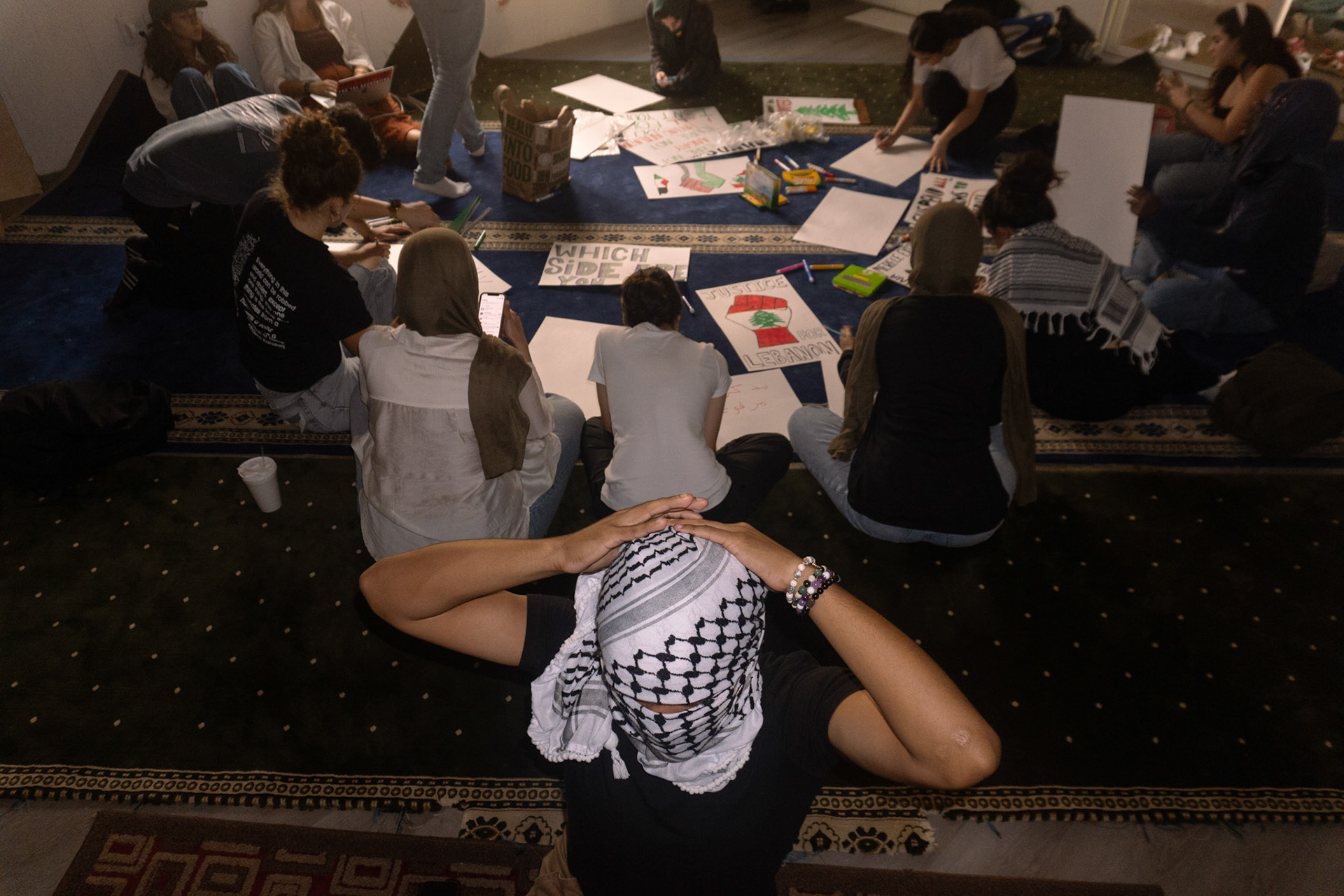 PSC member Ryan ties a keffiyeh during poster making at Nueces Mosque on Sept. 24, 2024.