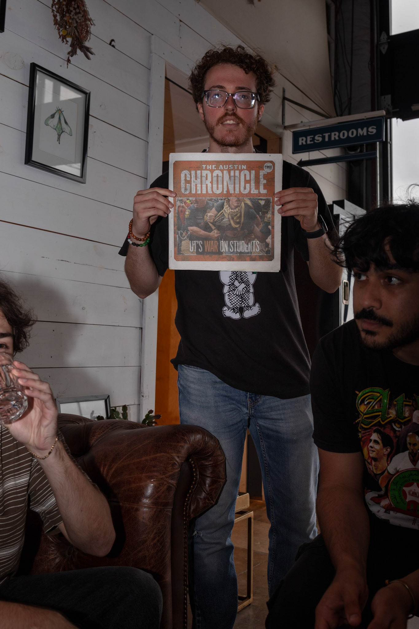 Qaddumi poses with a copy of The Austin Chronicle featuring his arrest on May 5, 2024.