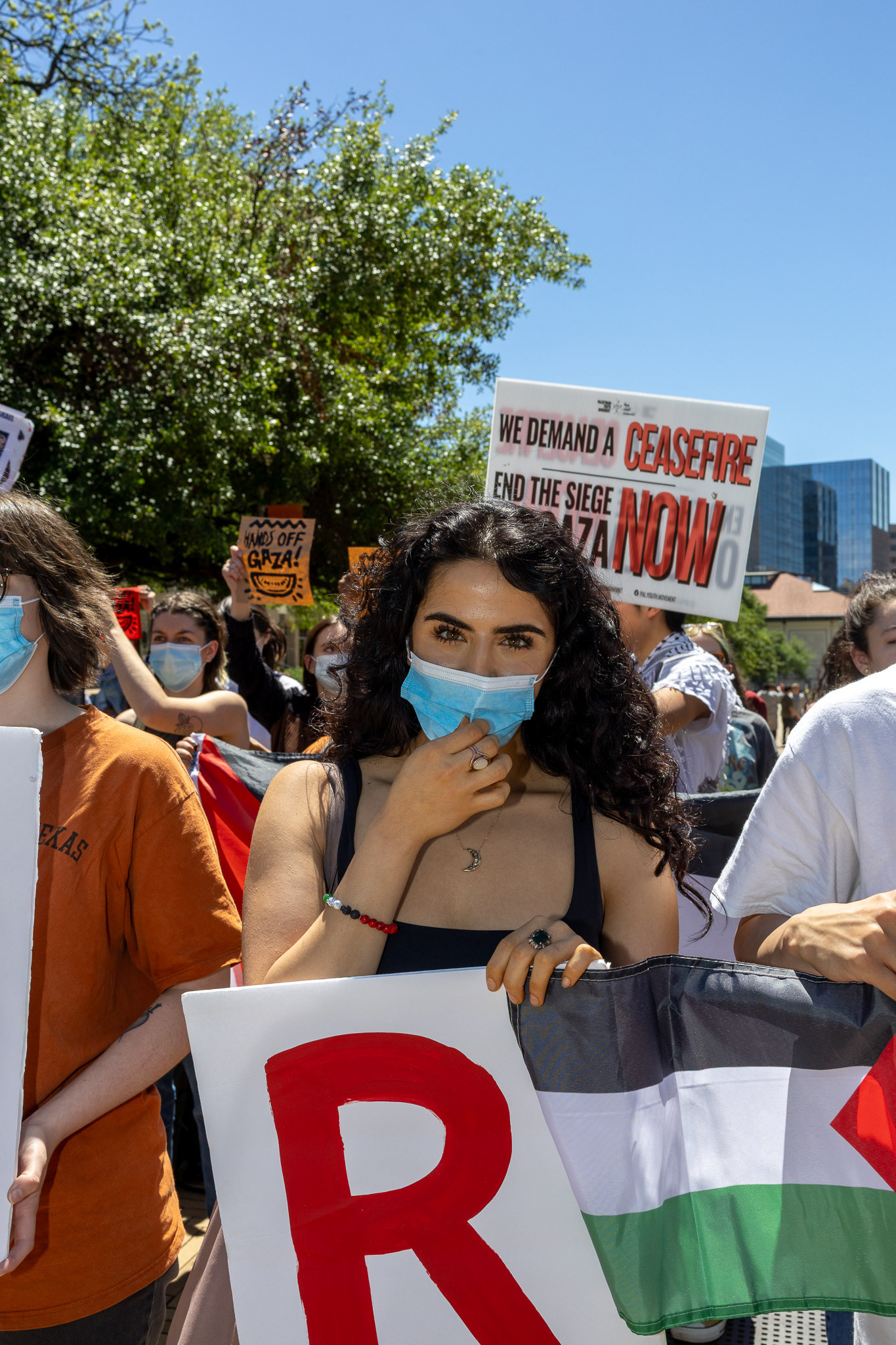 Rayan A., a student demonstrator of Palestinian-decent, holds the R in "cease fire" during the Israeli Block Party protest at The University of Texas on April 2, 2024.