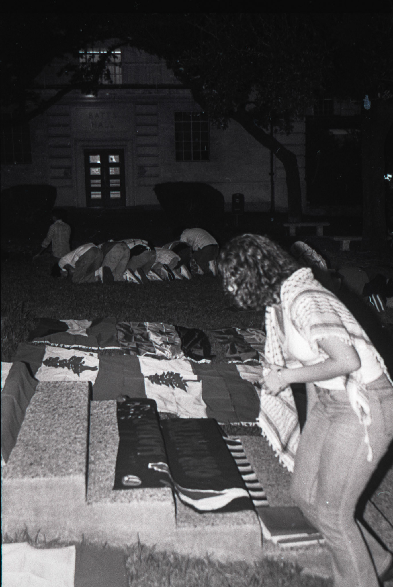 On the UT main lawn during maghrib prayer, Lamar Qaddumi folds flags after a vigil for Israel's invasion of Lebanon on Oct. 1, 2024.