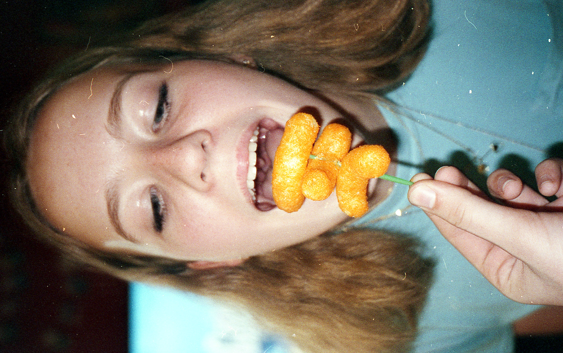 I feed cheese puffs to Audrey at her 16th birthday party.