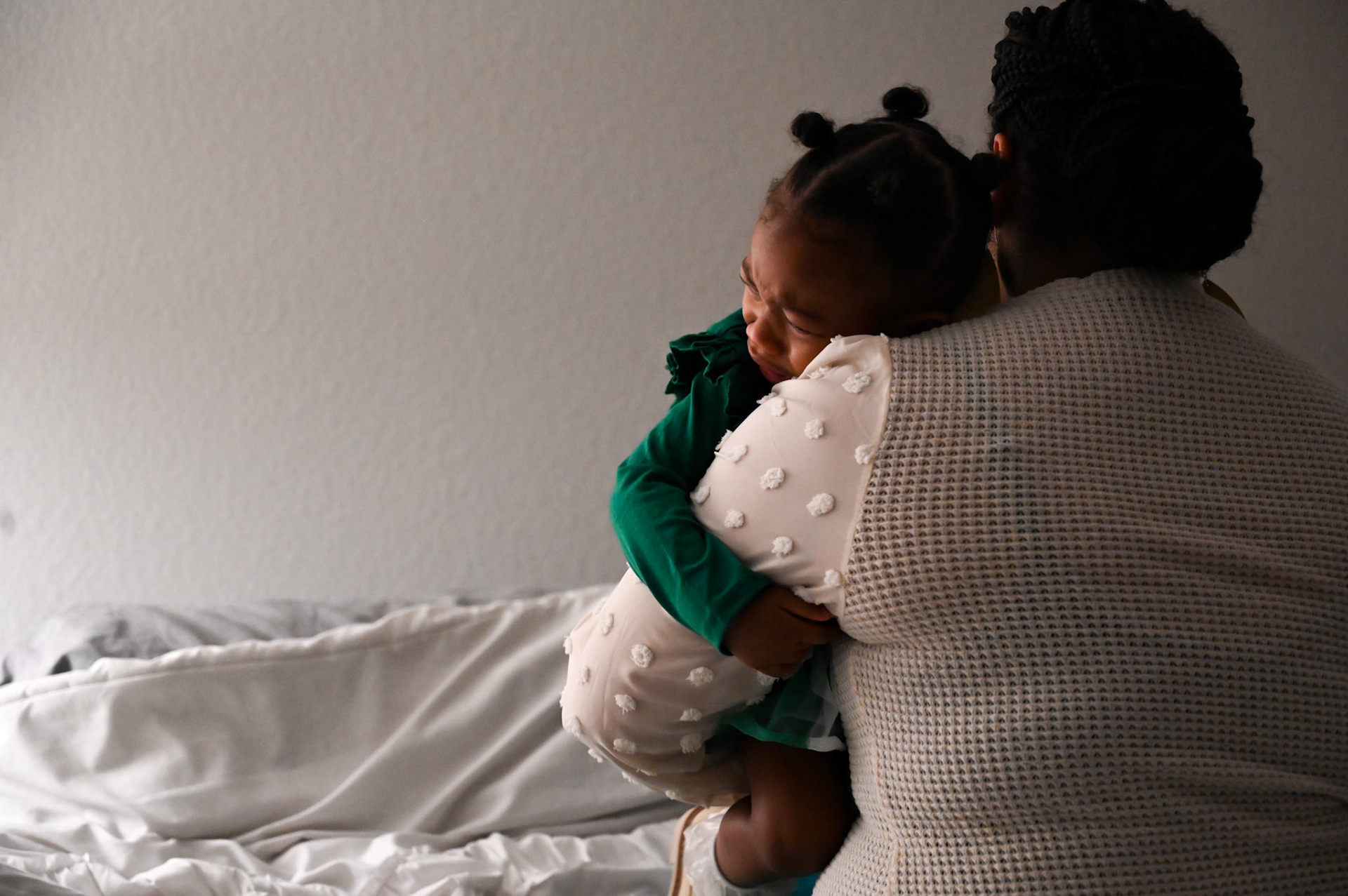 Alexandria Robertson comforts Novah Wilson on her bed in Manor, TX, on Feb. 2, 2023.