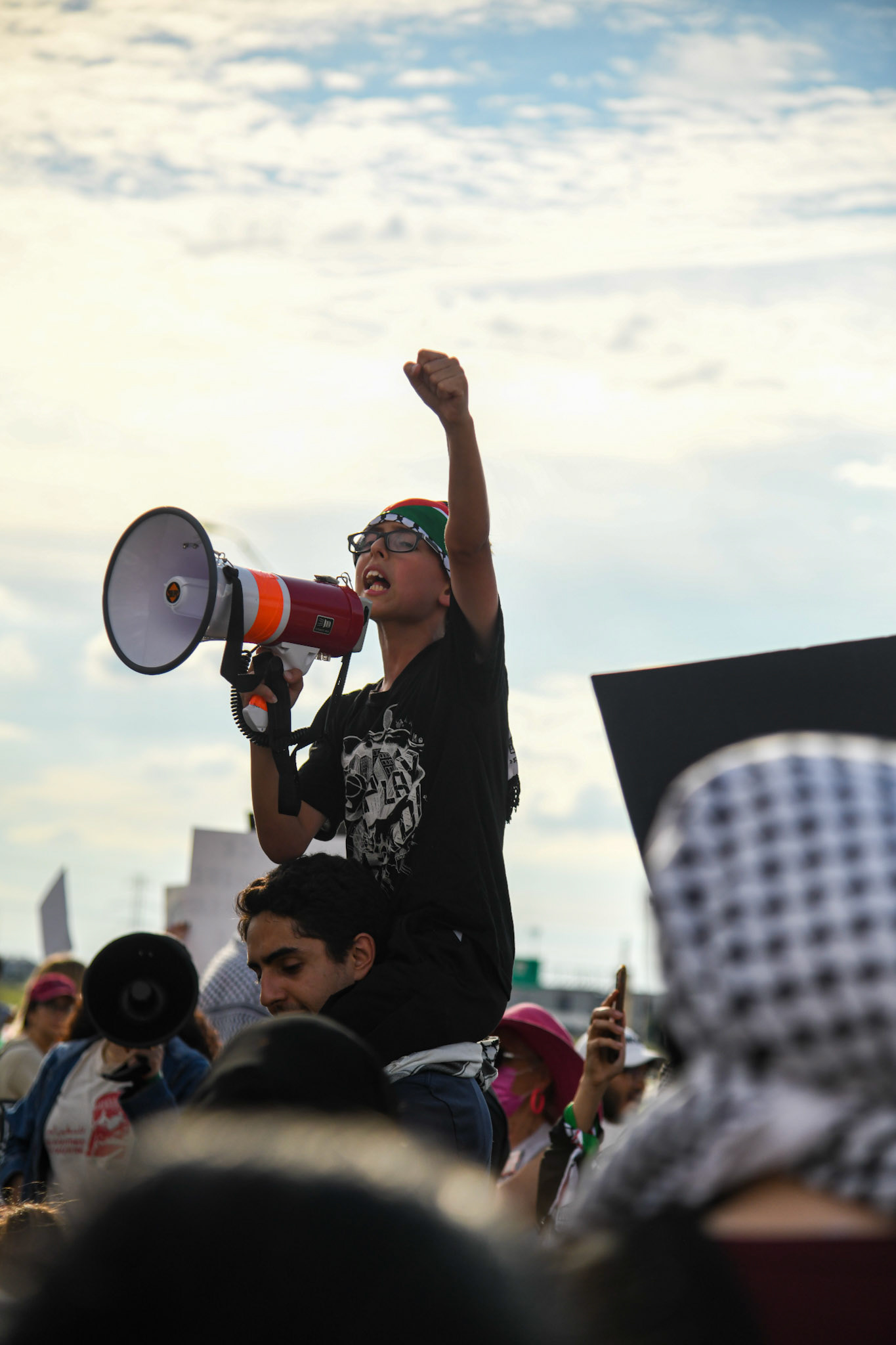 A young boy leads a chant at a Palestine liberation protest at Raytheon in Richardson, Texas on June 4, 2021. Shot for The Dallas Morning News.