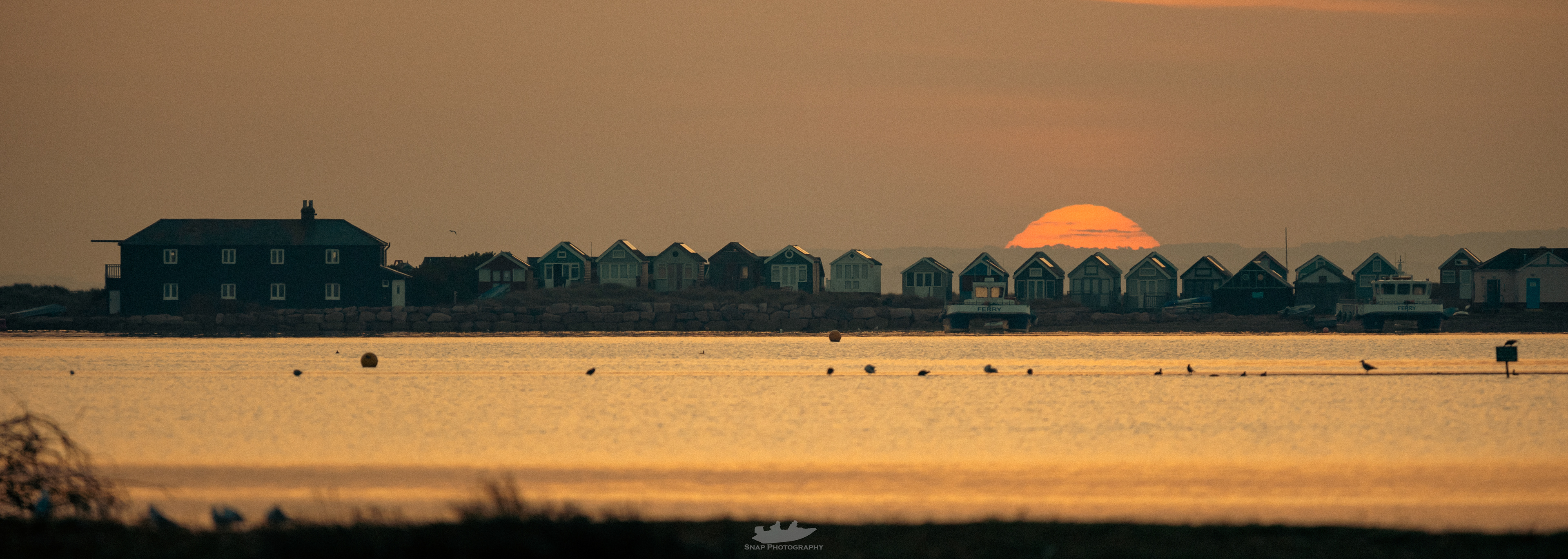 Sunrise over the beach huts at Hengistbury Head