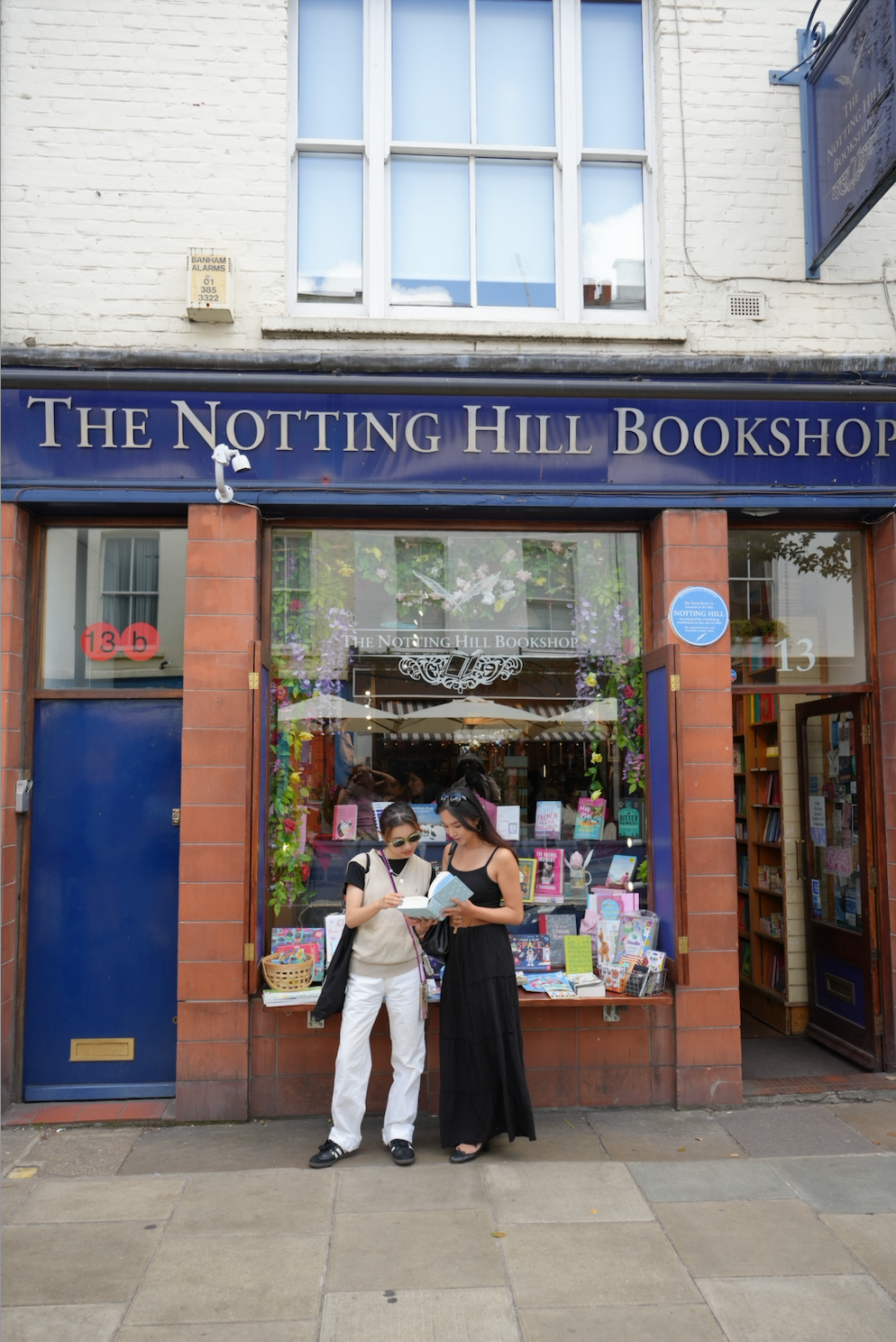 Mia and Nozomi reading outside The Notting Hill Bookshop (@ohlalamia_ and @nnnnnozomi)