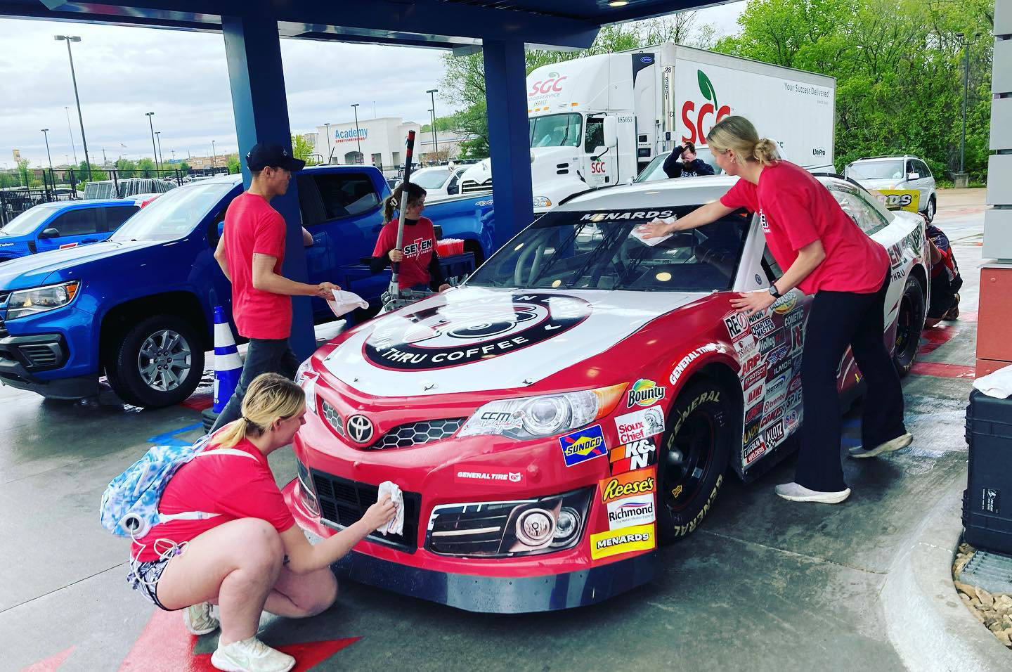 7-Brew employees take pictures with the car