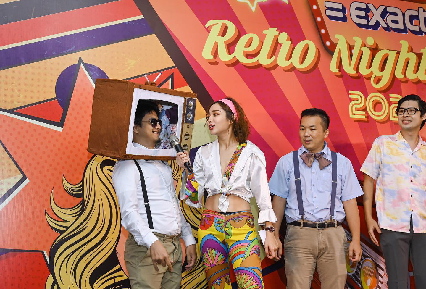 Emcee interacting with guests in funny costumes during a Retro Night theme dinner, celebrating the best-dressed participants.