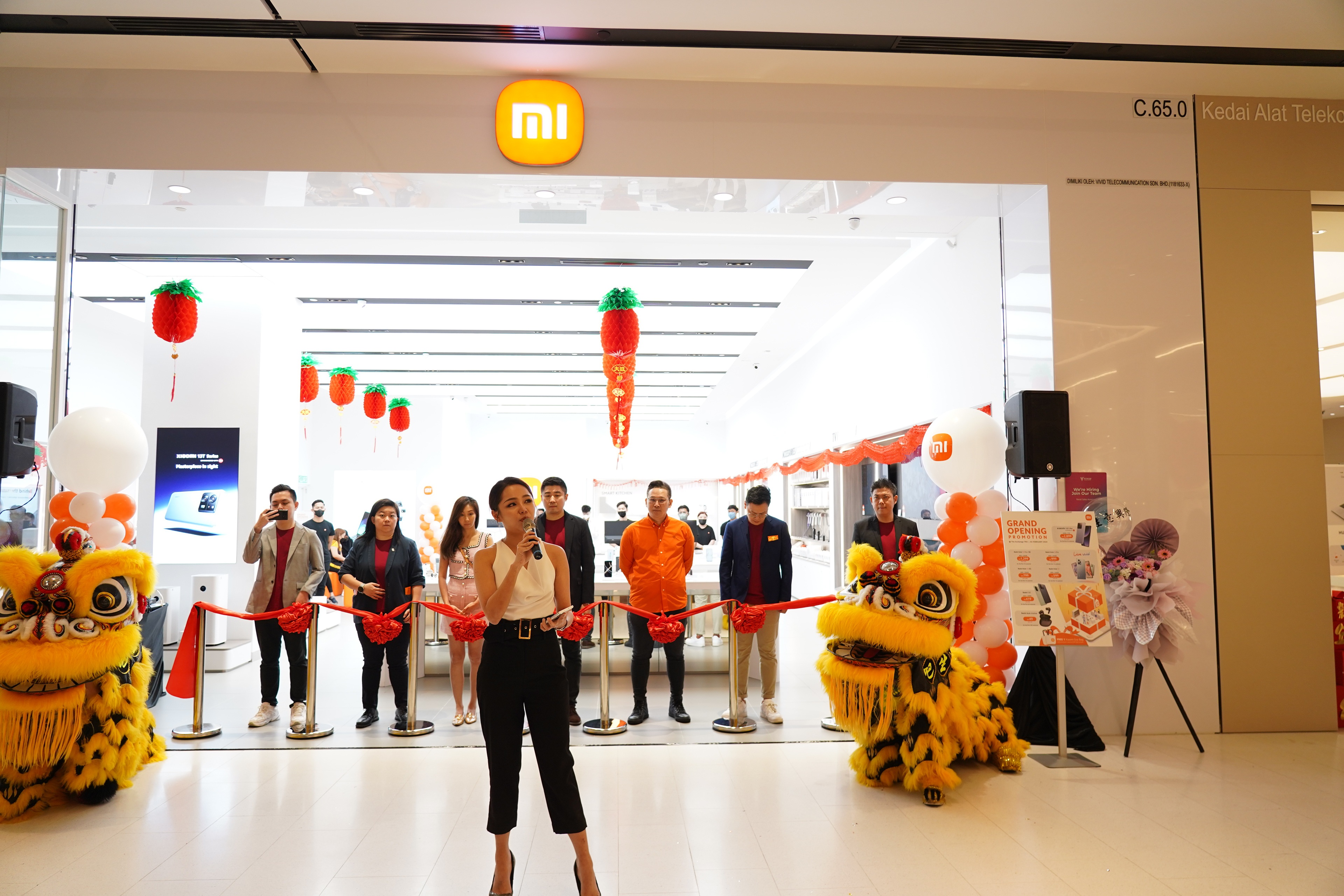 Dynamic emcee leading a grand opening event with ribbon cutting and excited guests