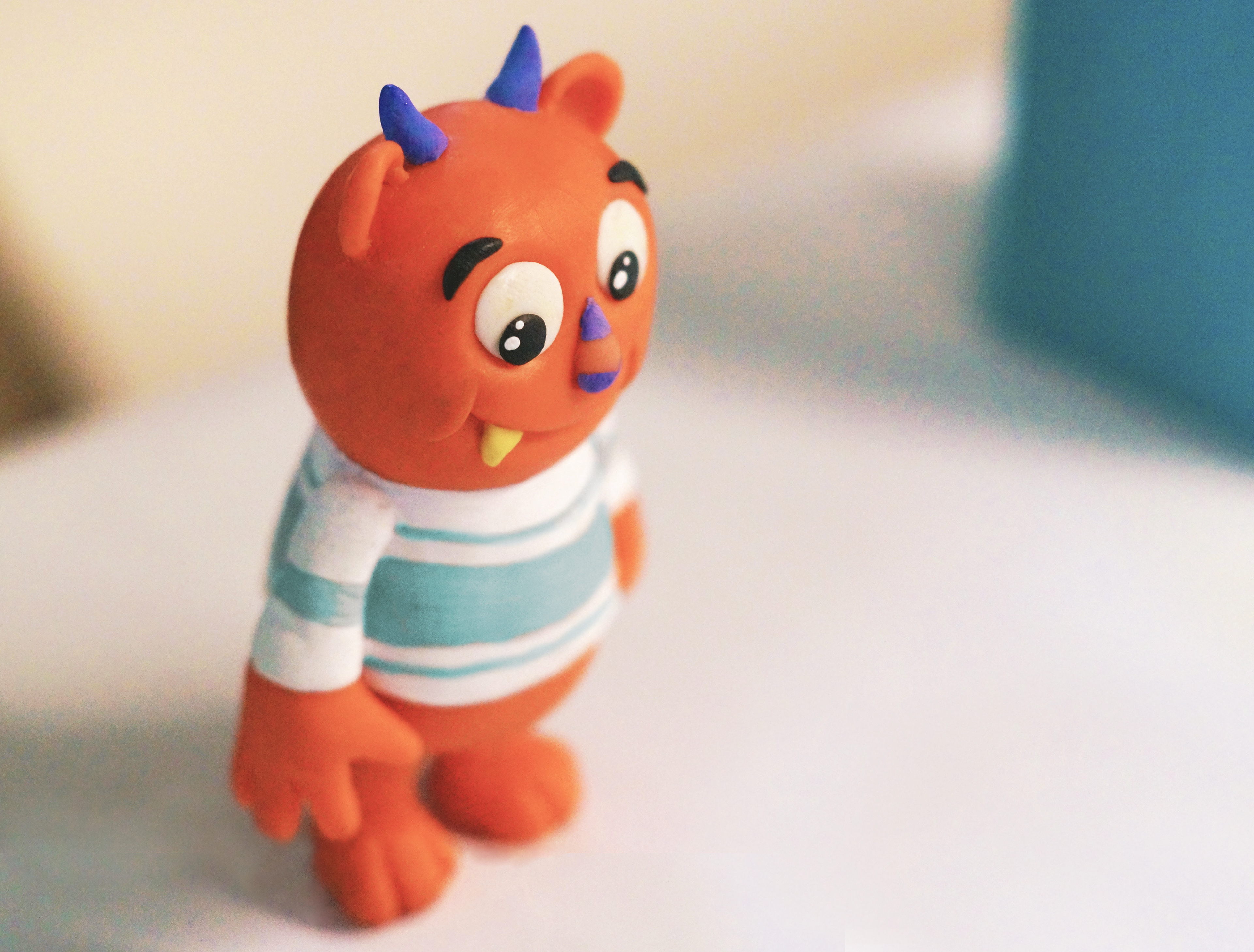 3D model of a sweet little bear-like monster, with a teacher, big eyes, and salmon-colored fur.
