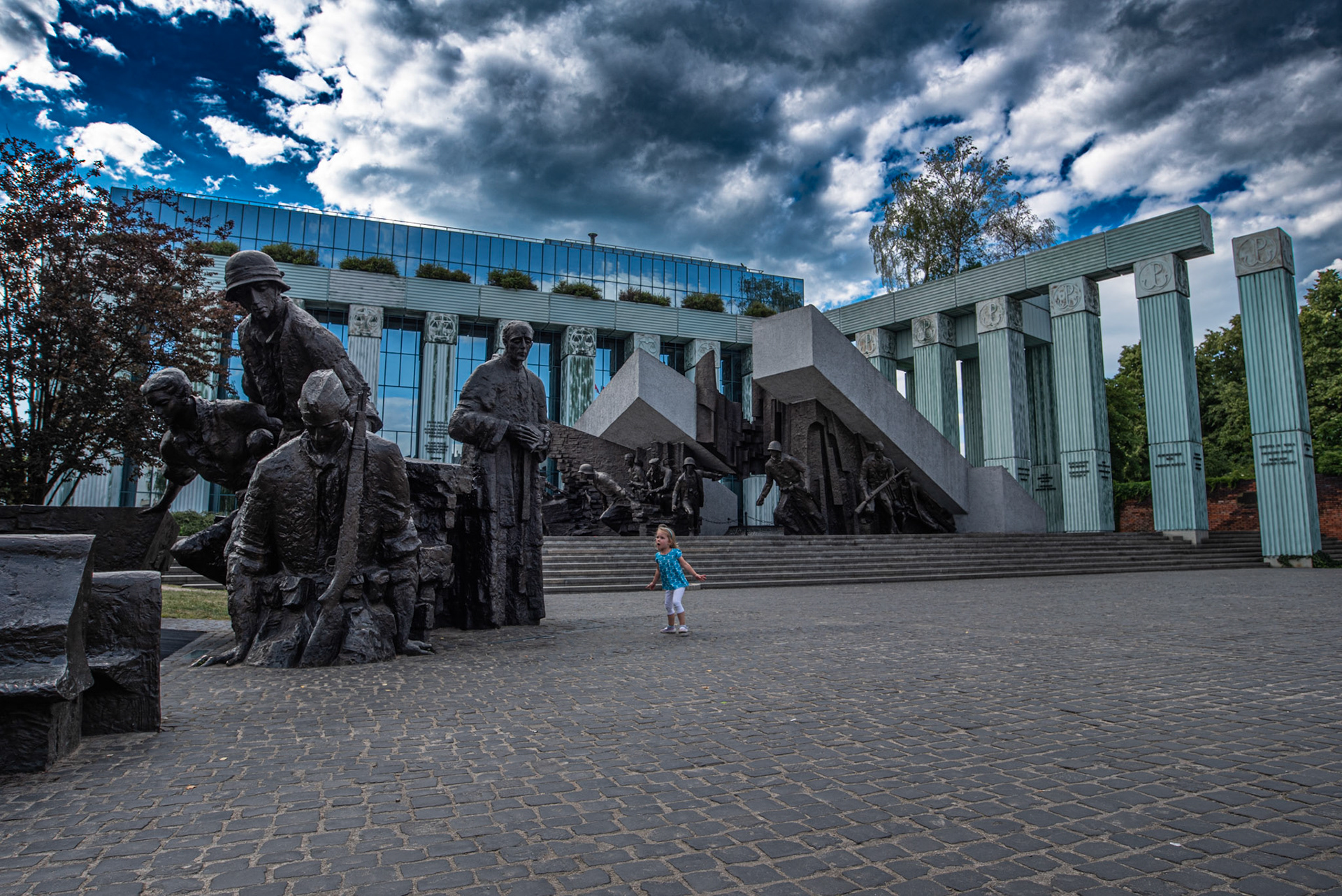 Accidental capture of an Unknown little girl shocked by soldiers emerging towards uprising; overshadowed by the clouded Lions.