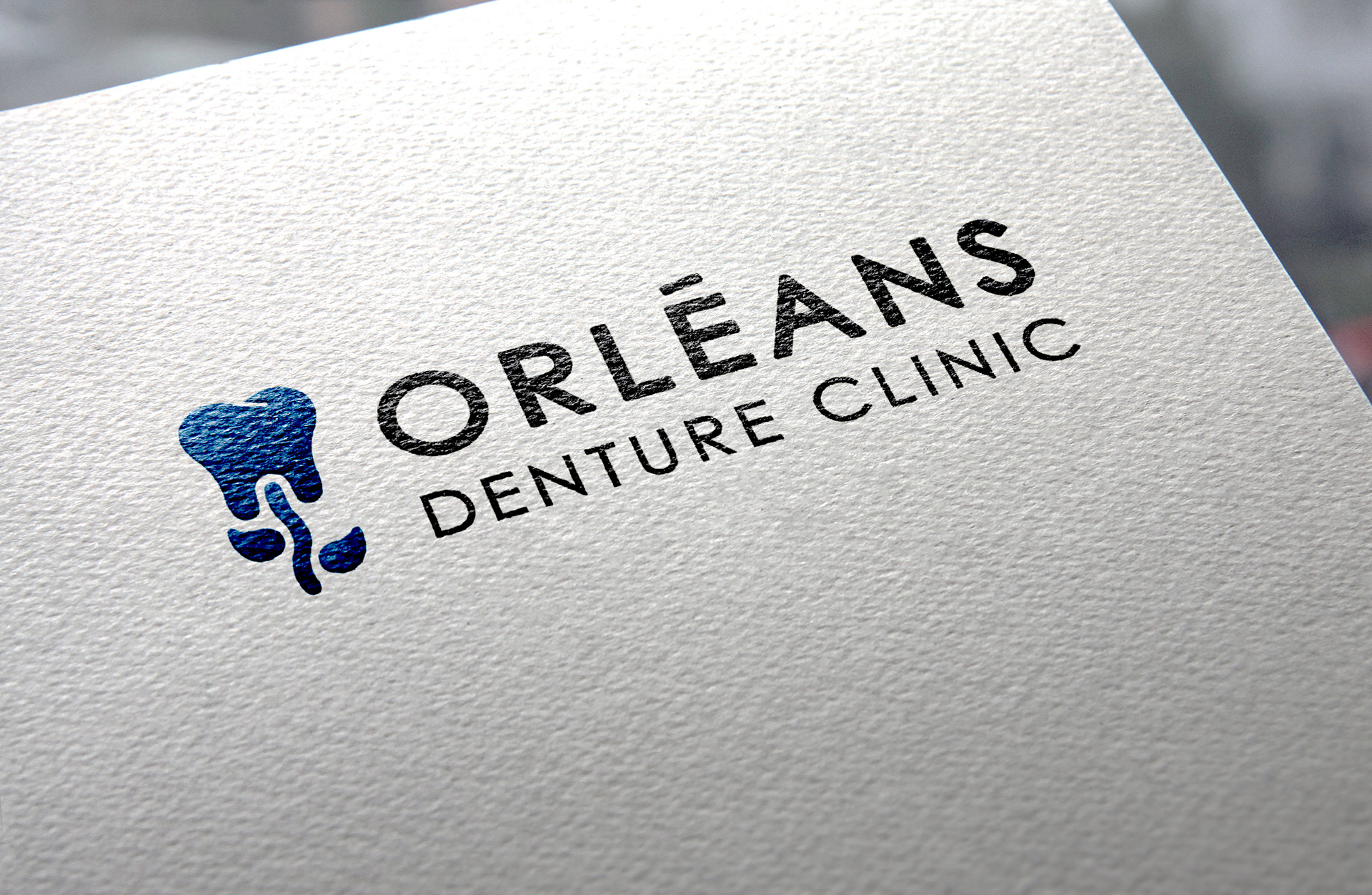 Mockup of Orléans Denture Clinic logo on textured paper.