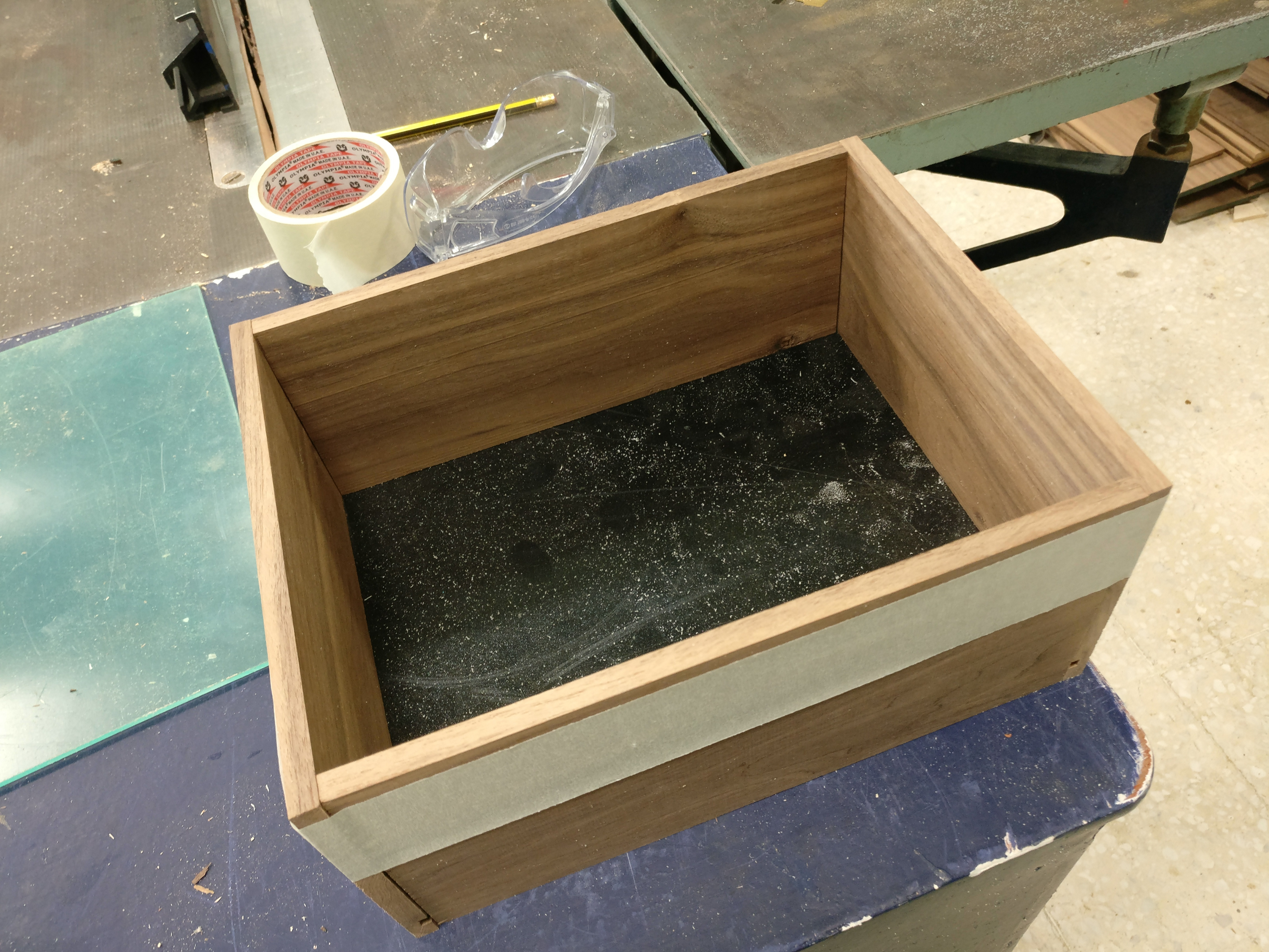 The wooden drawer is made out of walnut wood with a black acrylic base