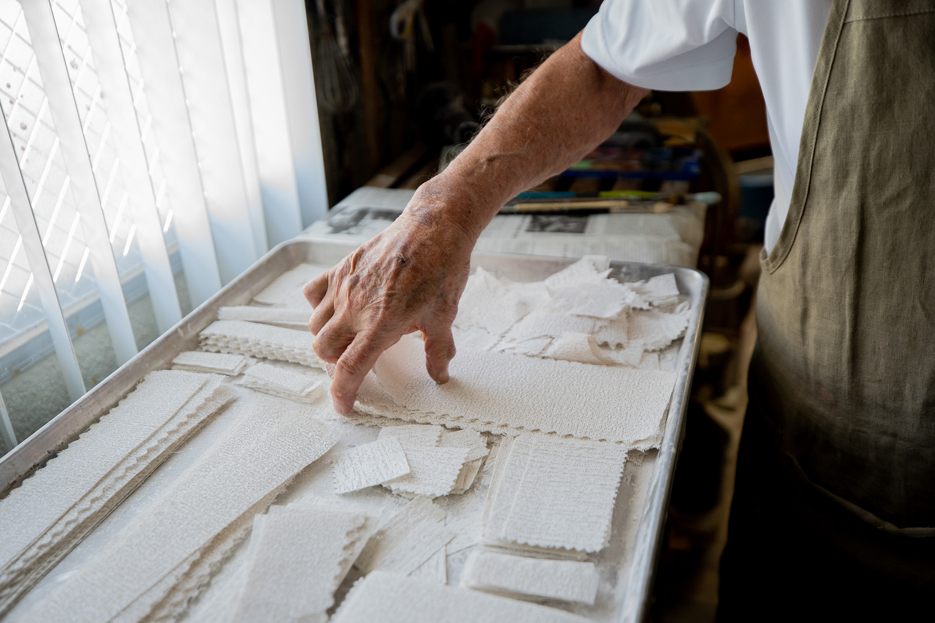 Artist Robert Sutz reaches for a plaster strip at his studio in Scottsdale on Feb. 12, 2022. The strips are the same cloth material medical personnel use to make casts for broken bones, he says. (Photo by Samantha Chow/Cronkite News)
