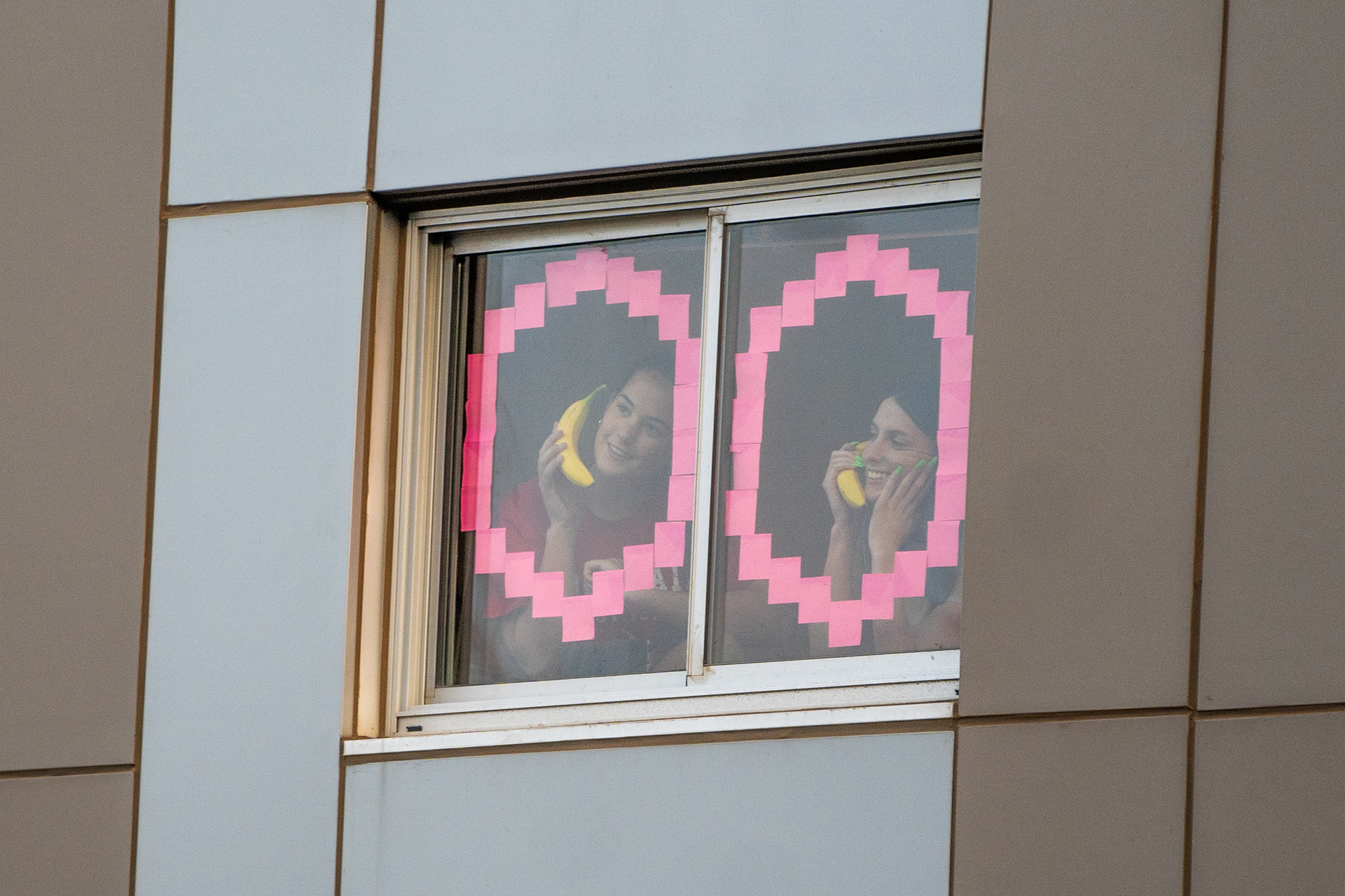 Roommates Shelby Fletcher and Sarah Conine pose for a photo in their dorm room window at Taylor Place on Sept. 16, 2020. (Samantha Chow/State Press)