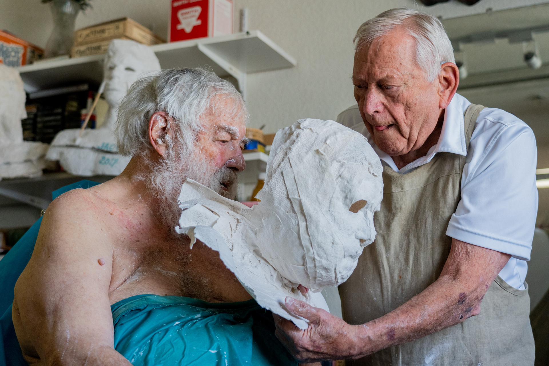 Artist Robert Sutz removes a dried life mask from Holocaust survivor Werner Salinger’s face at his art studio in Scottsdale on Feb. 12, 2022. For approximately 30 years, Sutz has made life masks of about 200 other “Holocaust survivors, liberators and righteous gentiles.” (Photo by Samantha Chow/Cronkite News)