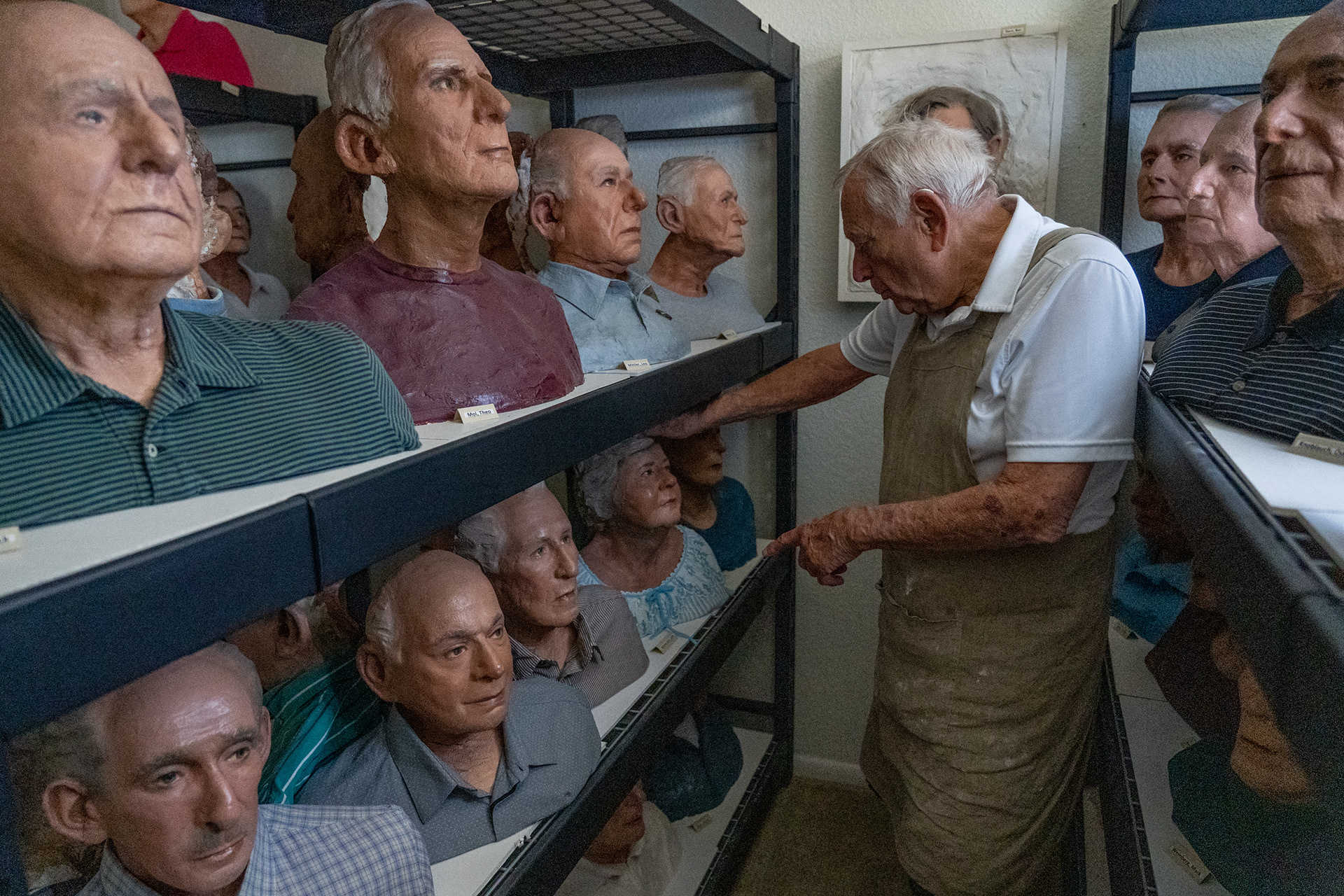 Robert Sutz looks at some of his completed life masks at his art studio in Scottsdale on Feb. 12, 2022. He began making the masks in the 1990s while working for Steven Spielberg’s Shoah Foundation. (Photo by Samantha Chow/Cronkite News)