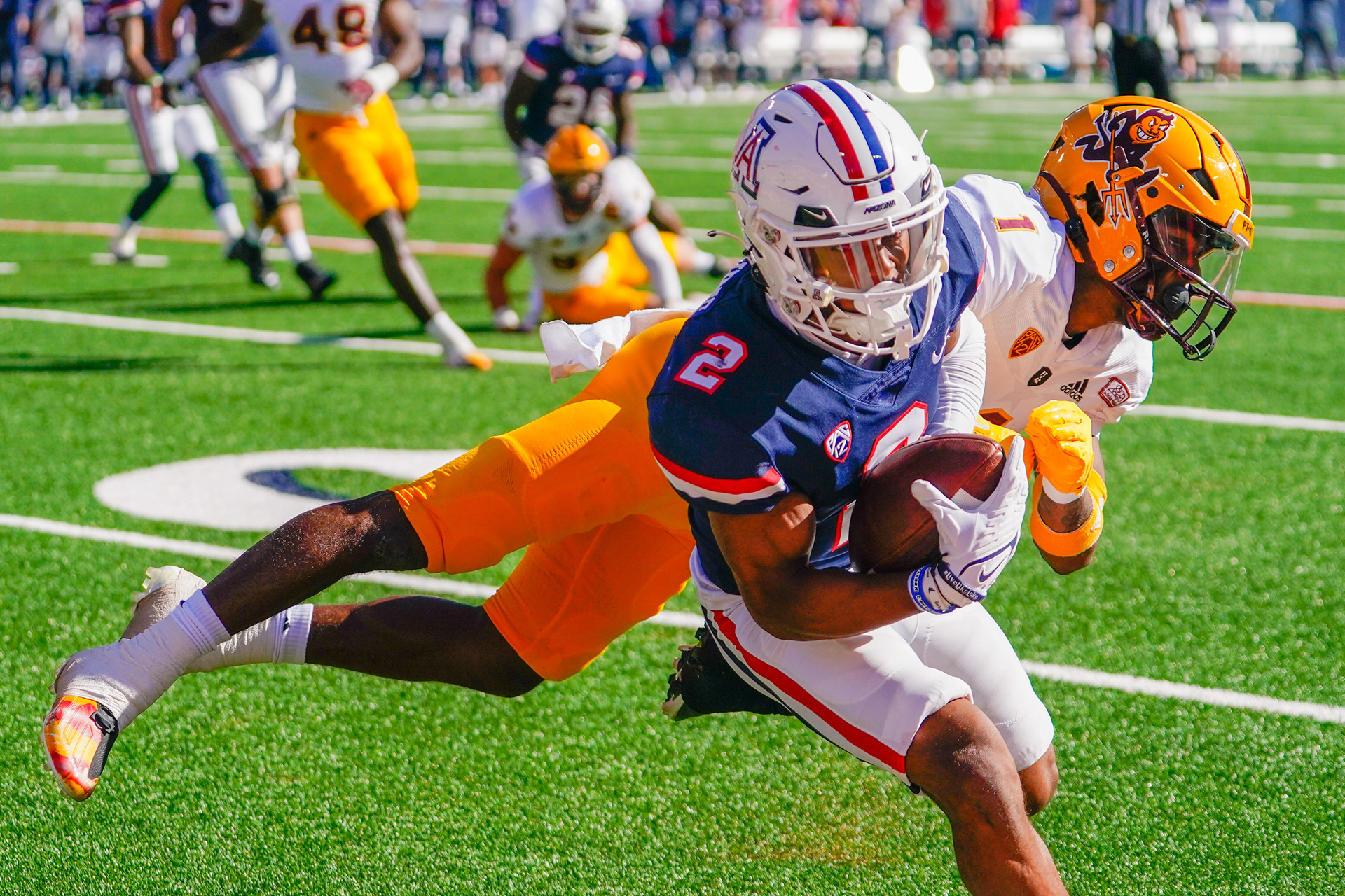 University Arizona wide receiver Jacob Cowing (2) dodges a tackle by Arizona State defensive back Jordan Clark (1) during the first half of the Territorial Cup game at Arizona Stadium in Tucson on Nov. 19, 2022. (Samantha Chow/Arizona State University)