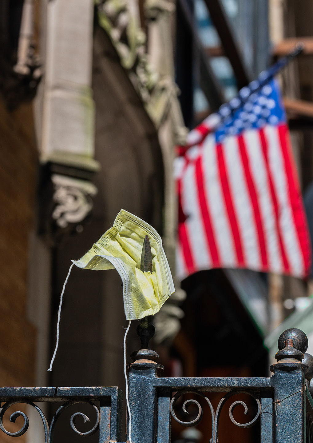 Surgical mask pushed onto spike of wraught iron fence in NYC.