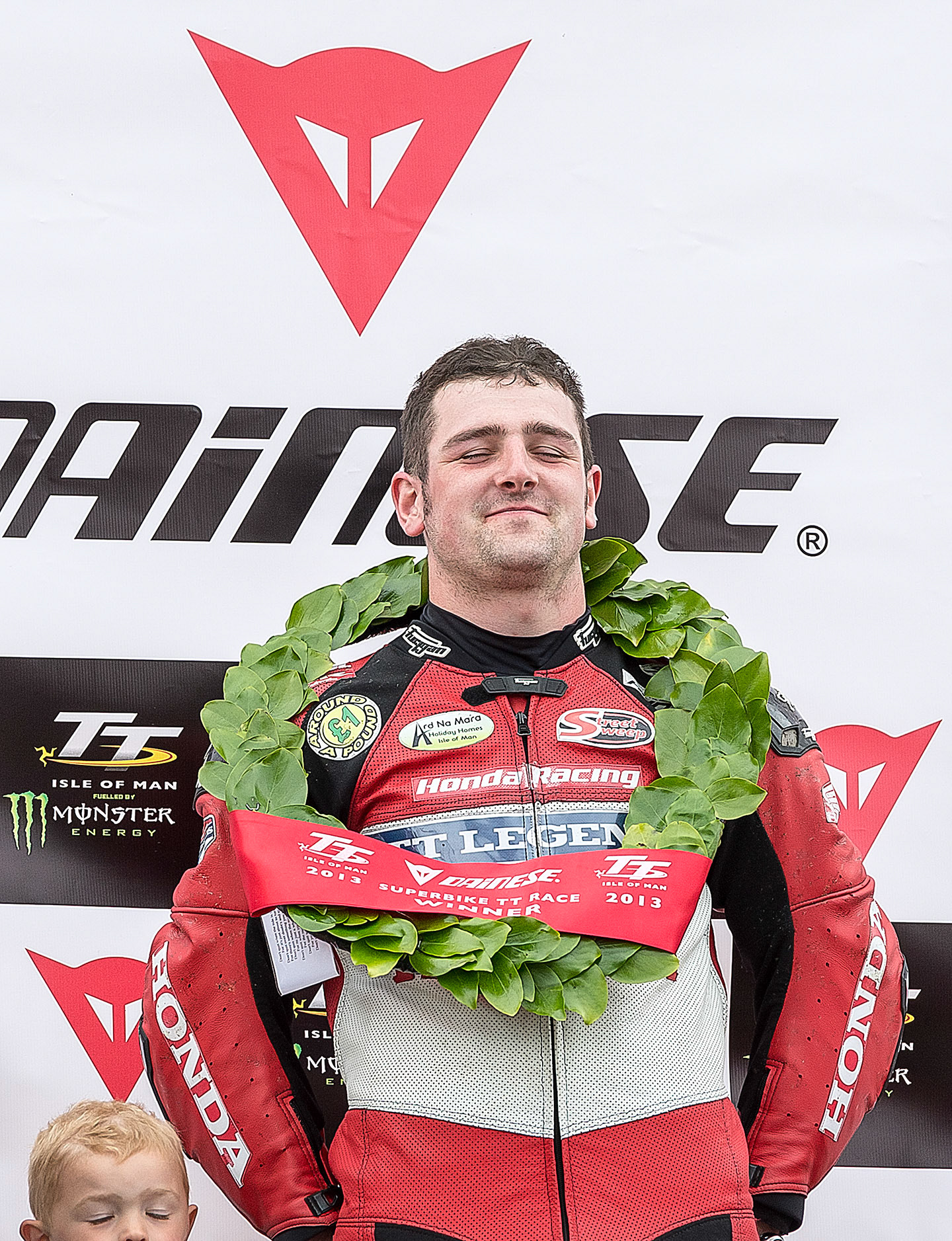 Michael Dunlop with a friends son, Jack Burrows, on the podium after winning the SuperBike race at the Isle of Man TT.