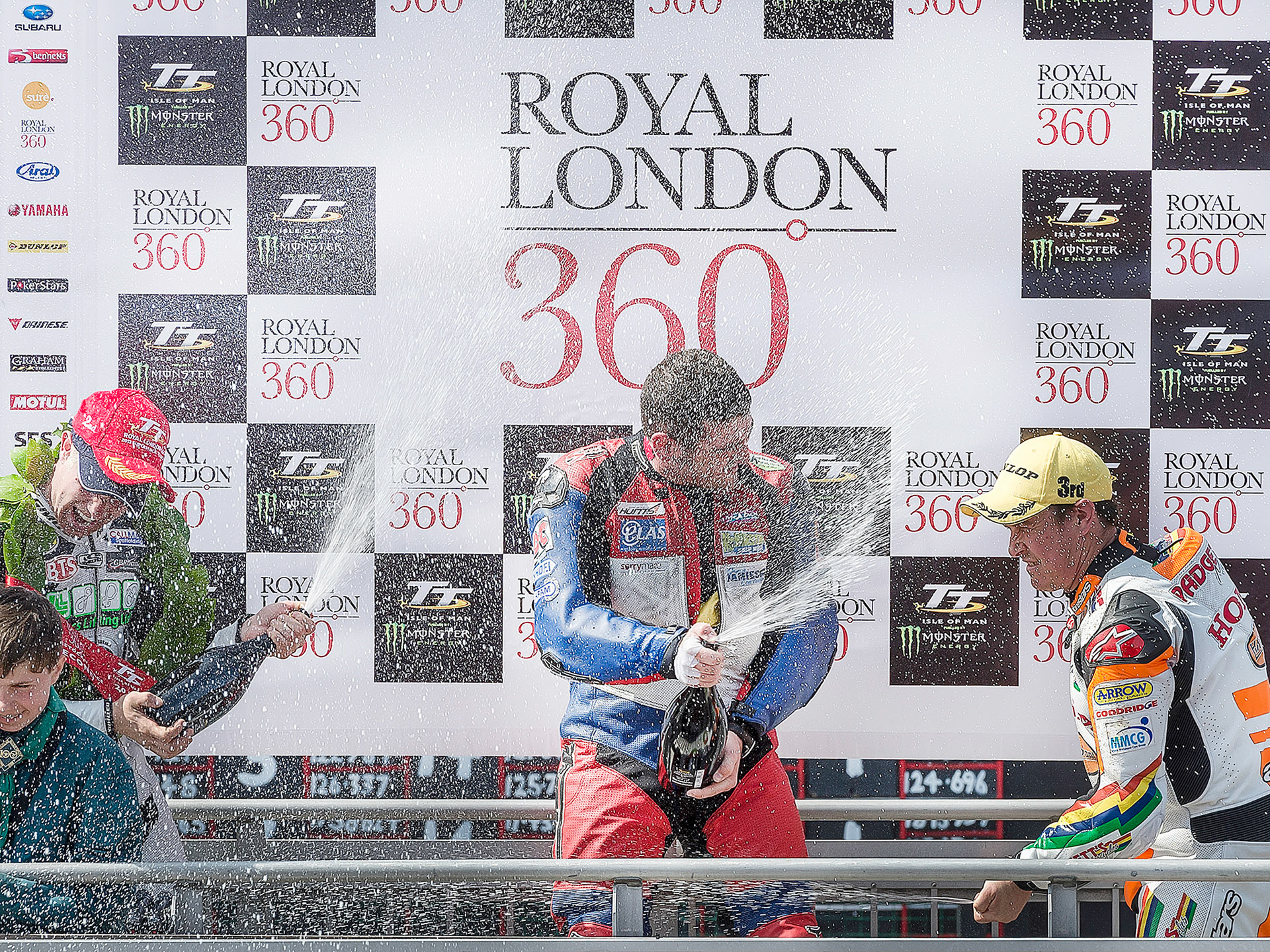 Michael Dunlop celebrates another win, the Dainese SuperStock Race, at the 2013 Isle of Man TT with Gary Johnson (L) and John McGuinness (r)