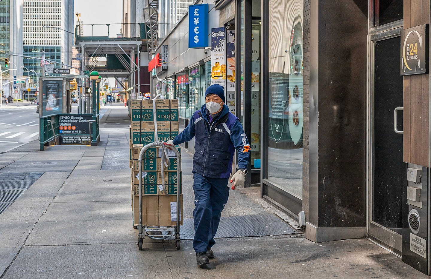 Lone FedEx delivery man on empty sidewalk in NYC during COVID19 Lock down.