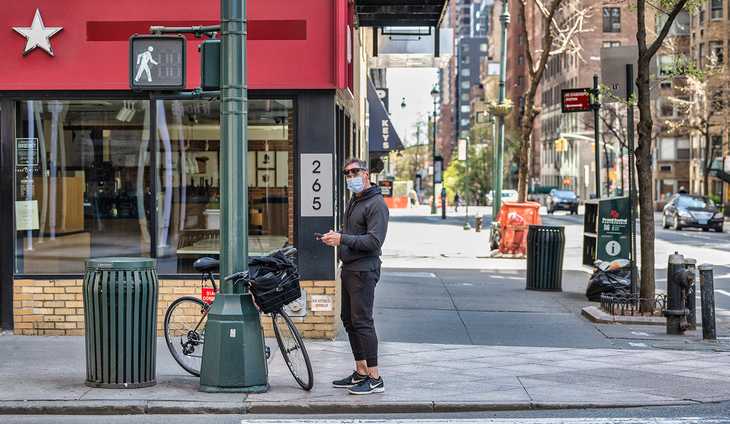Man takes a break during a bike ride to use his phone during COVID19 lockdown in NYC